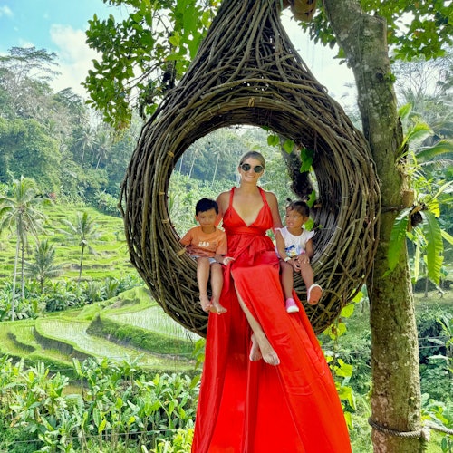 ビー・ネスト・フォトブースの中で、母親が二人の子供と一緒に座っています。