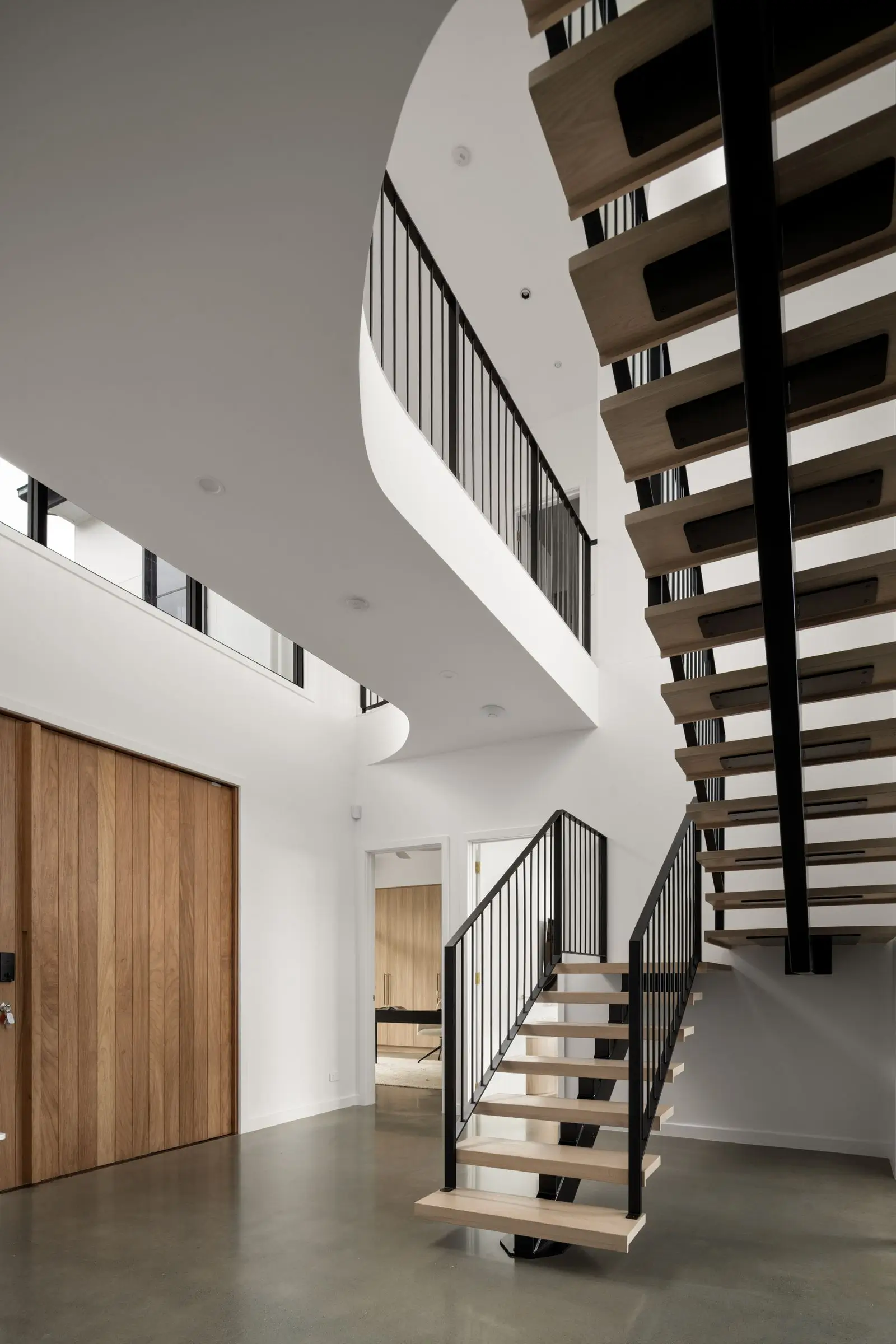 Open tread staircase upon entry to Lenore House designed by Invilla Architecture