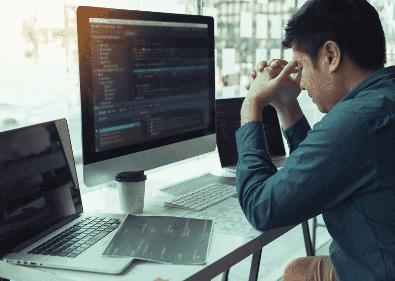 Man holding head with software code on computer