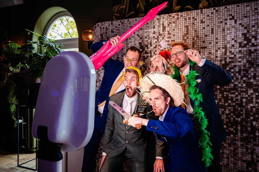 Wedding guests dressed up, taking a photo in the photobooth