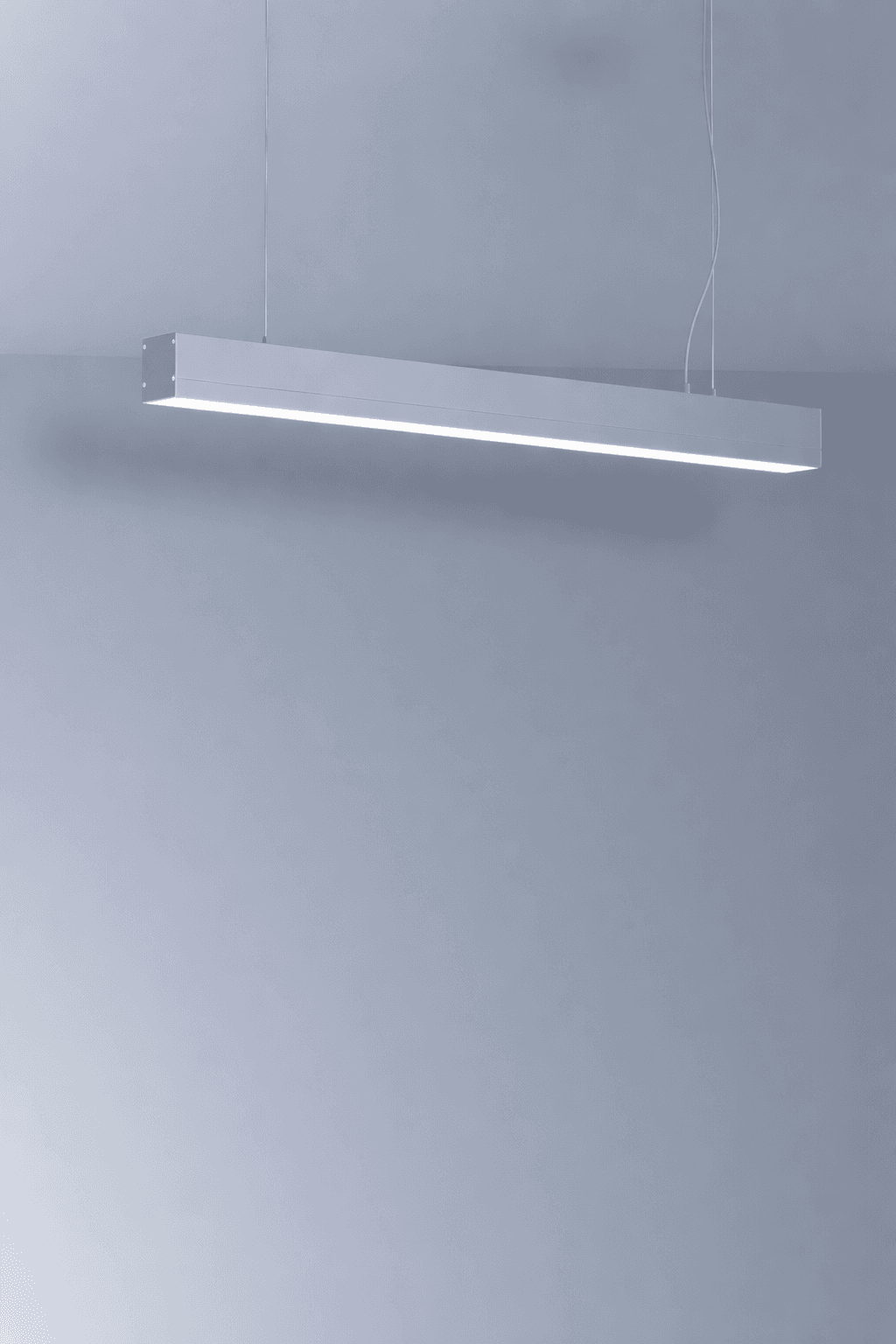 A lone figure walks along a rocky shore at sunset.