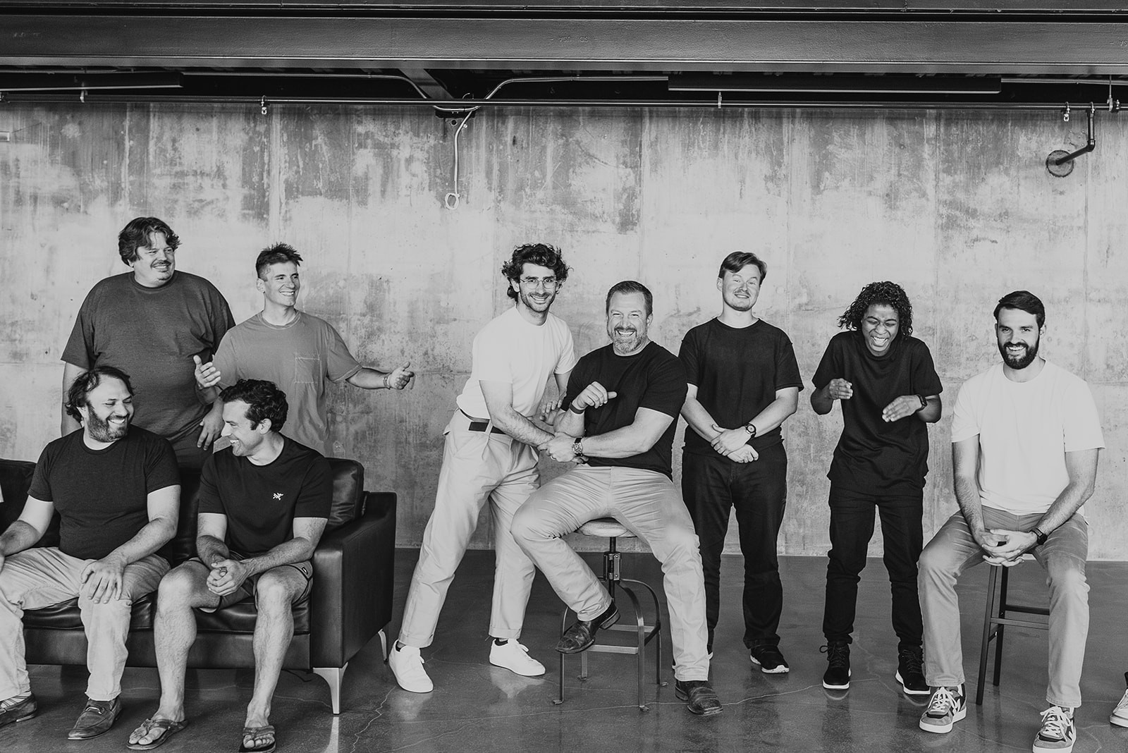  Collaborative work session overhead view of six people collaborating at a rustic wooden table with coffee, papers, and a laptop