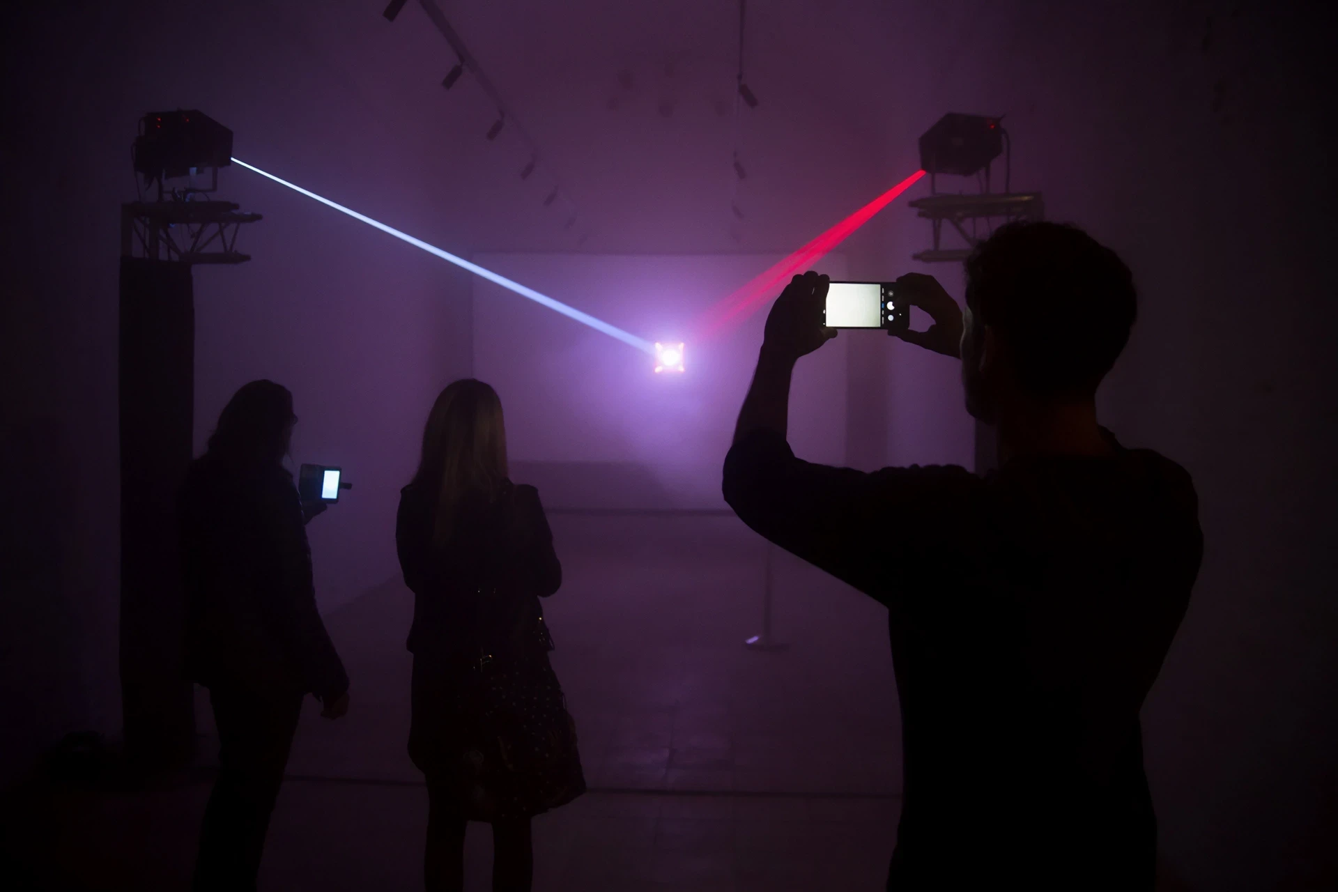Laser light show with people viewing and filming.