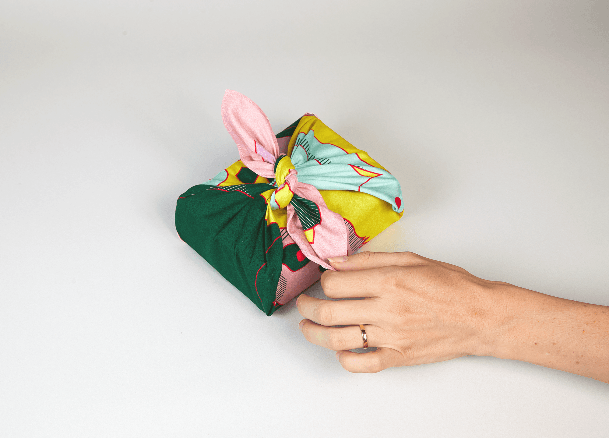 Close up of the Wrap a Tale furoshiki knot, highlighting the colorful illustrated fabric.