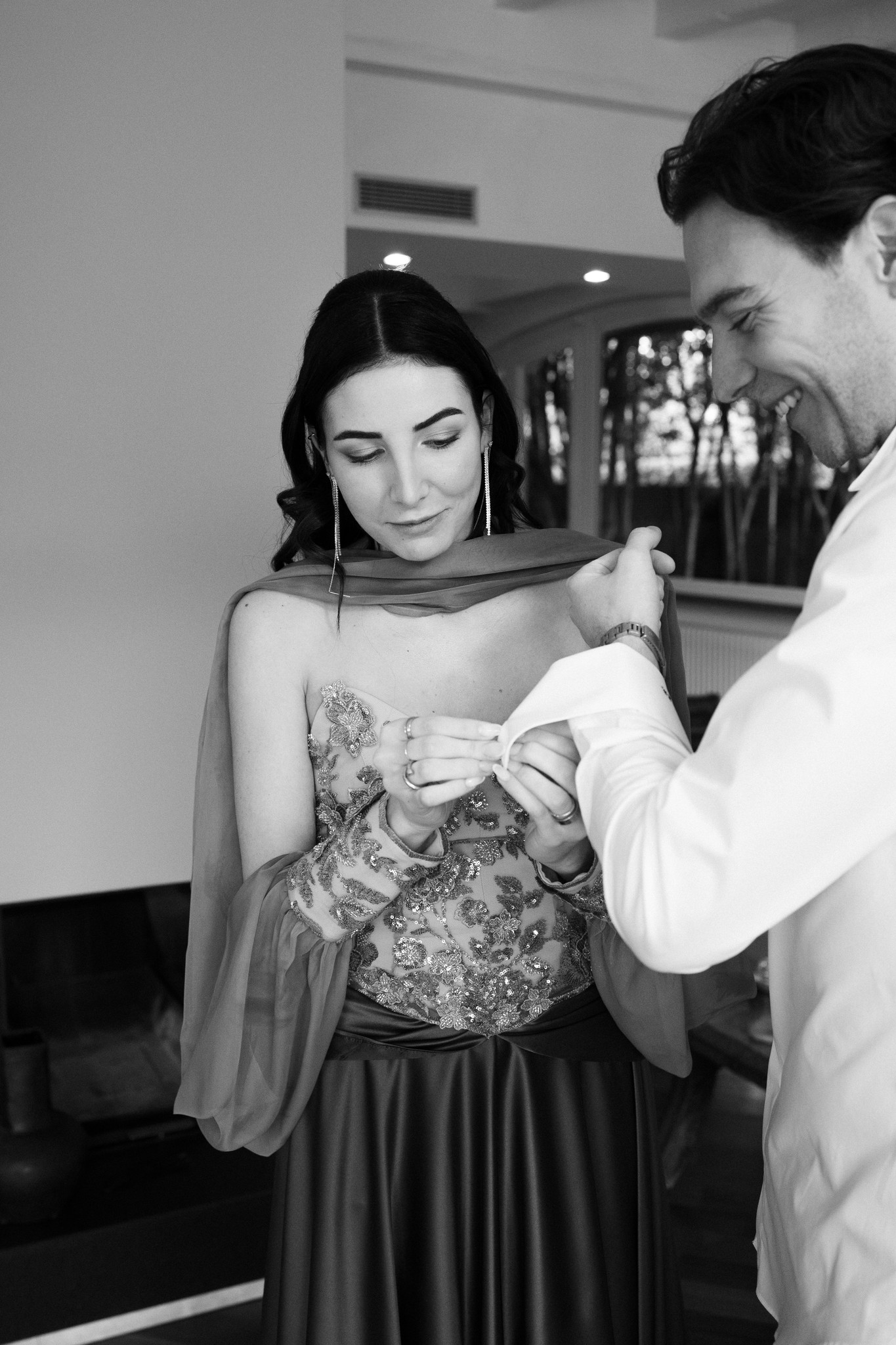 Sposa che indossa l'abito mentre lo sposo sistema il velo, preparativi intimi al Circolo di Lettura di Parma