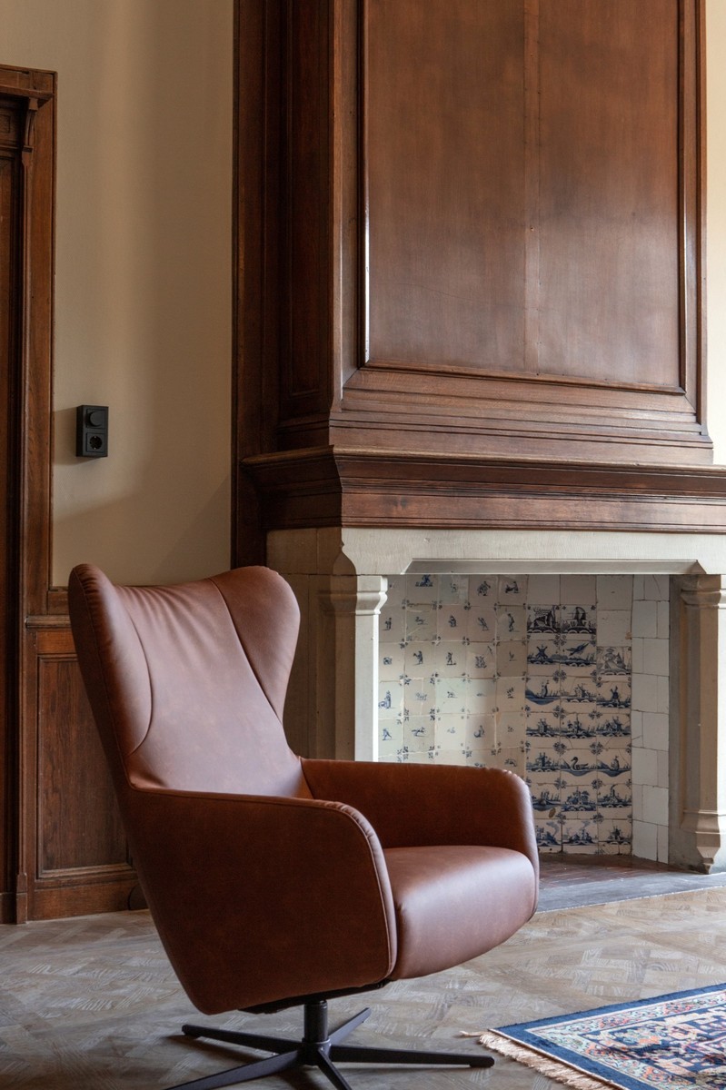 open haard met tegels en lounge stoel 