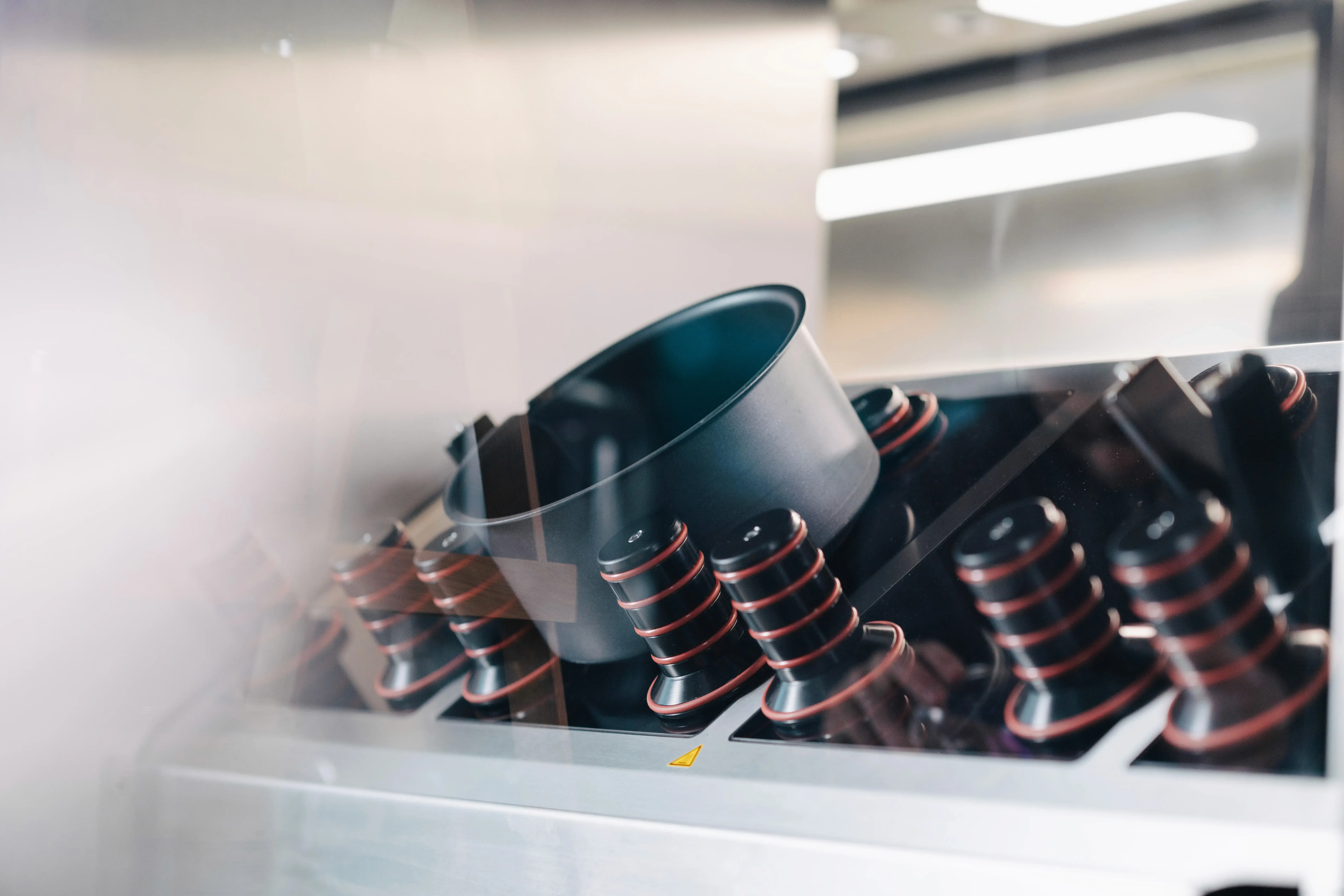 A close-up of a row of exercise equipment, featuring stationary bikes against a minimalist background.