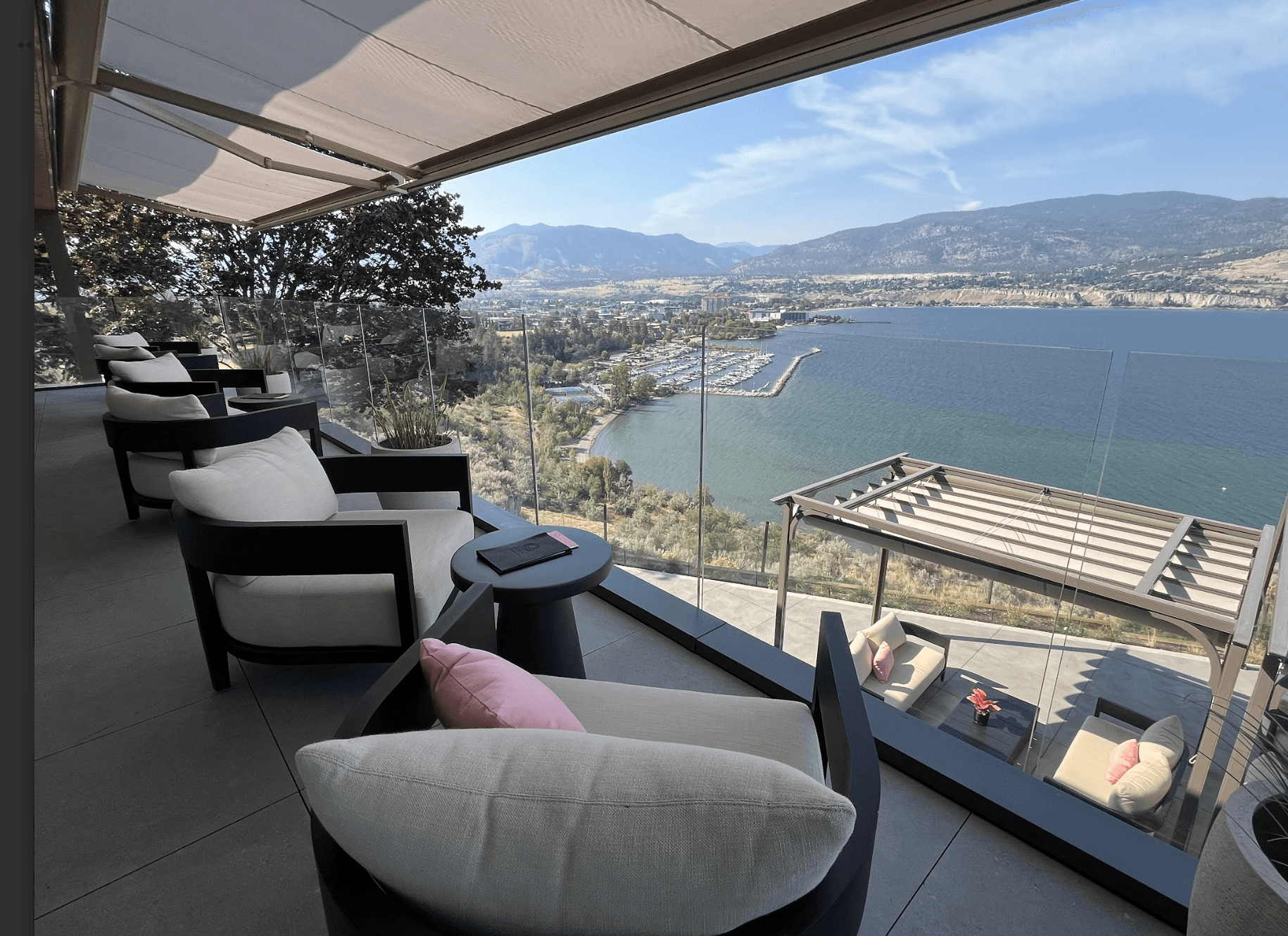 Glass railing on a covered patio with lake and mountain views