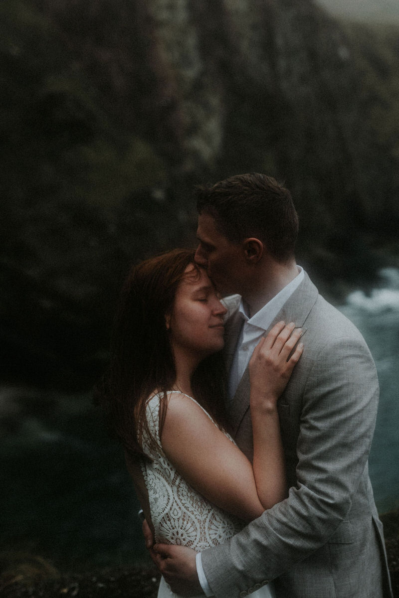 closeup of bride and groom kissing in the rain ireland coast
