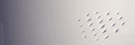 Multiple small drops of dog balm repeated across a neutral surface in a uniform arrangement