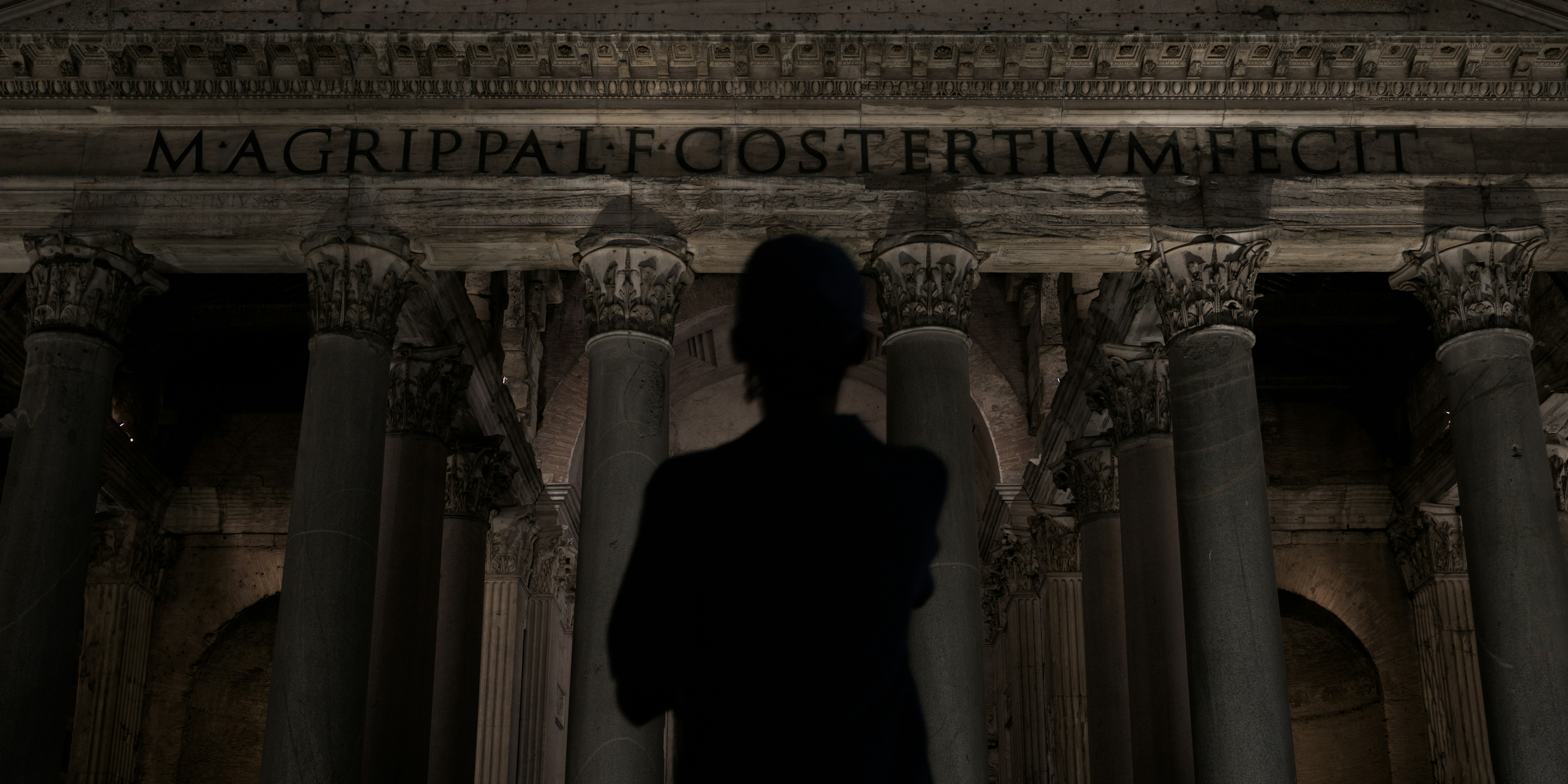 A silhouette before the columns of a monumental building