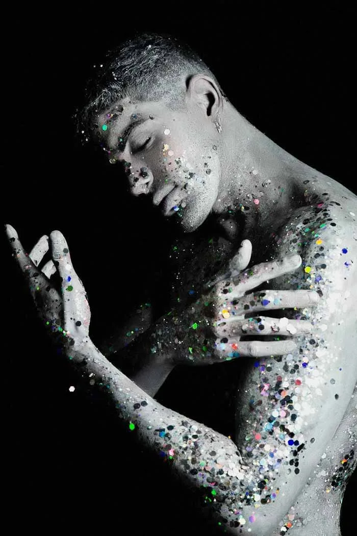 A lone astronaut sitting on a rocky surface, gazing at Earth from space.