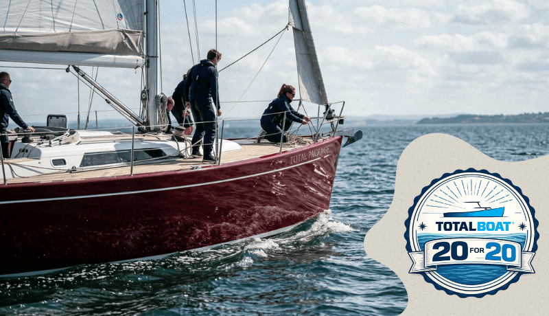 Crew sailing a red sailboat on open water with Total Boat 20 for 20 badge