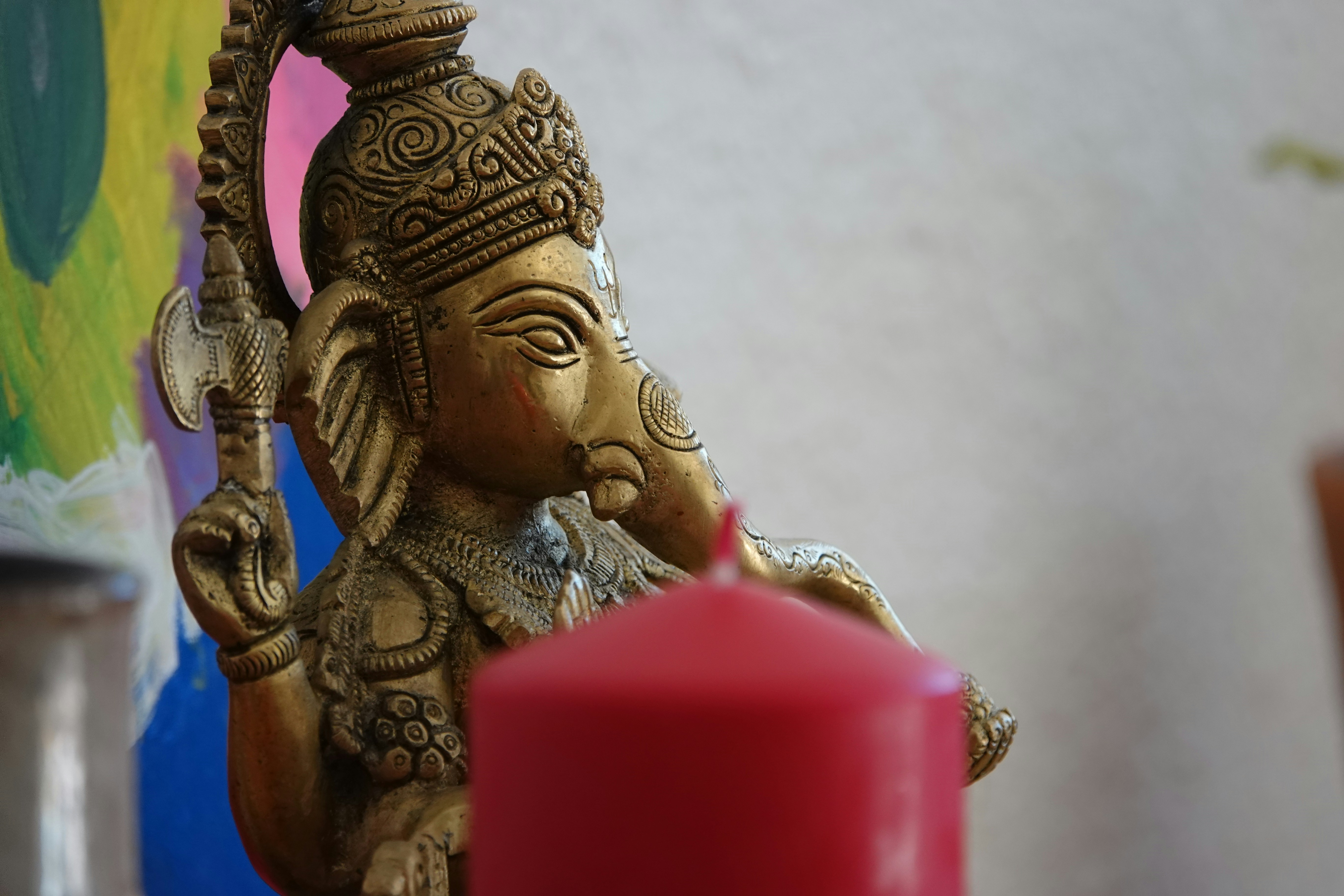 Une statue d'une personne tenant un objet rouge