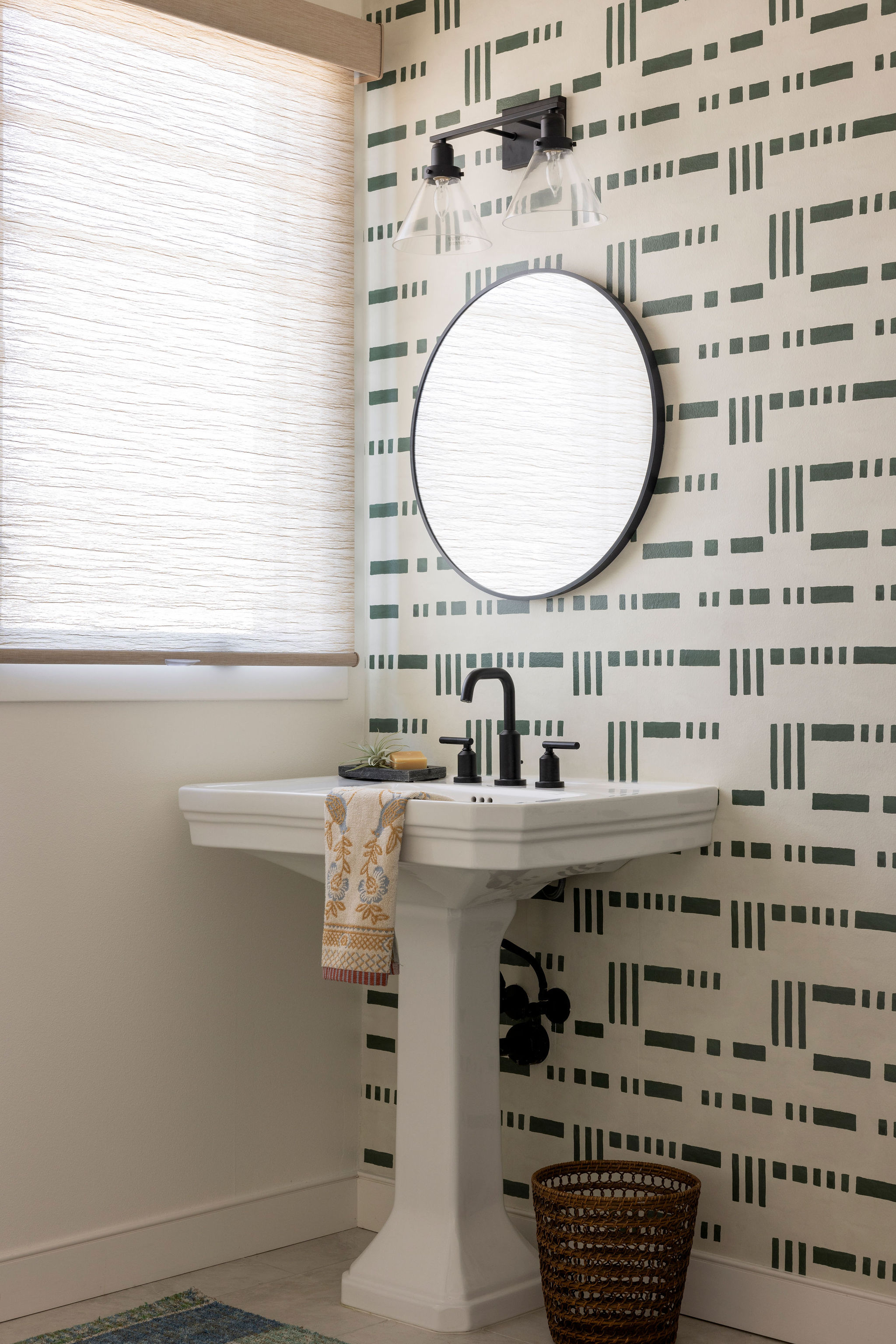 Sophisticated powder bath featuring a bold statement wallpaper and sleek modern fixtures that blends coastal charm with contemporary elegance.