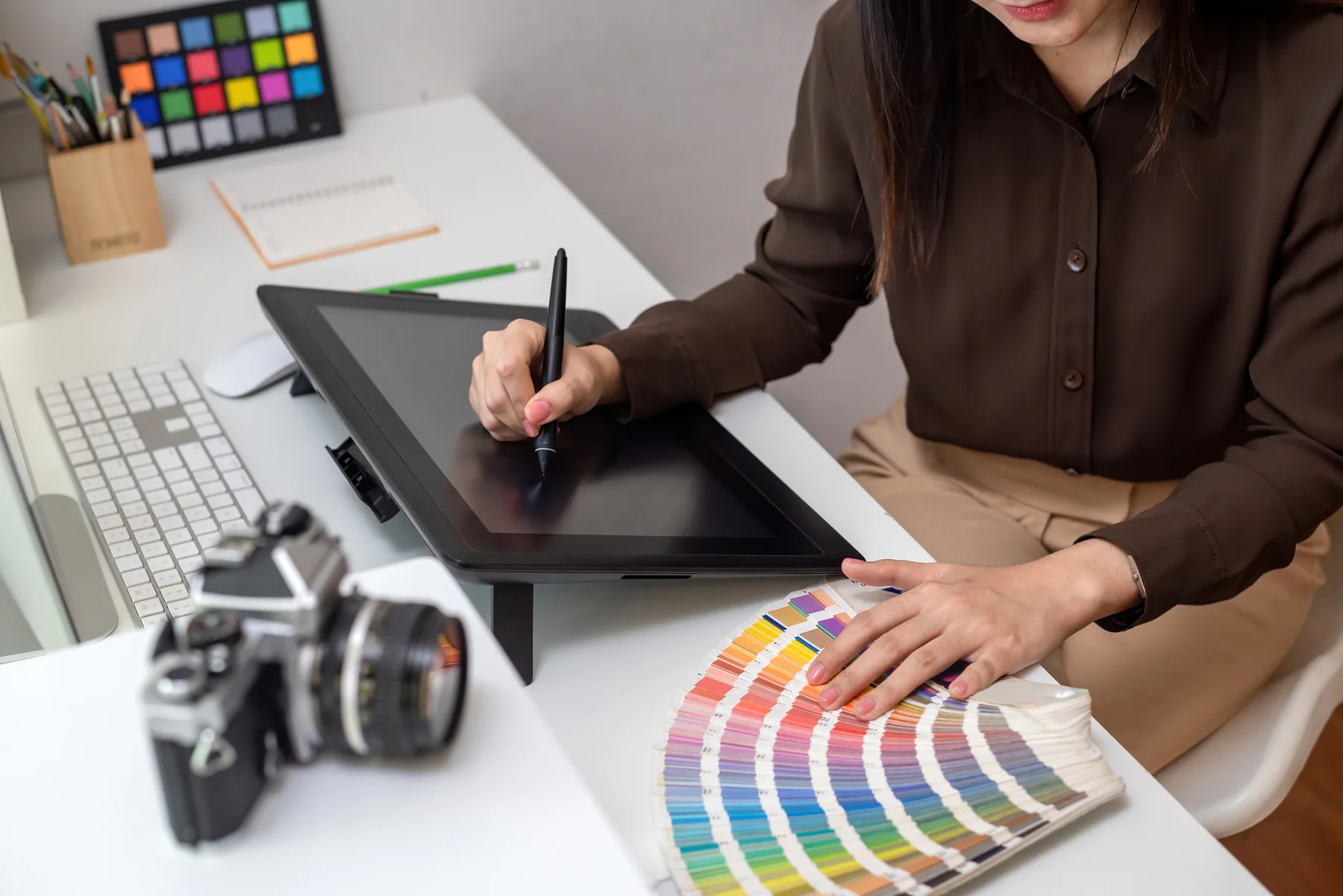 Female Artist Designs on Graphics Tablet At Desk