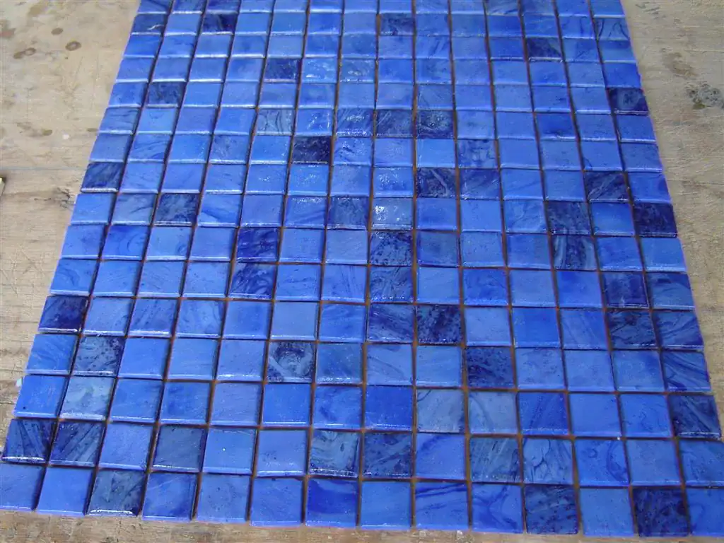 Blue mosaic pool border with Greek and Roman-inspired patterns.