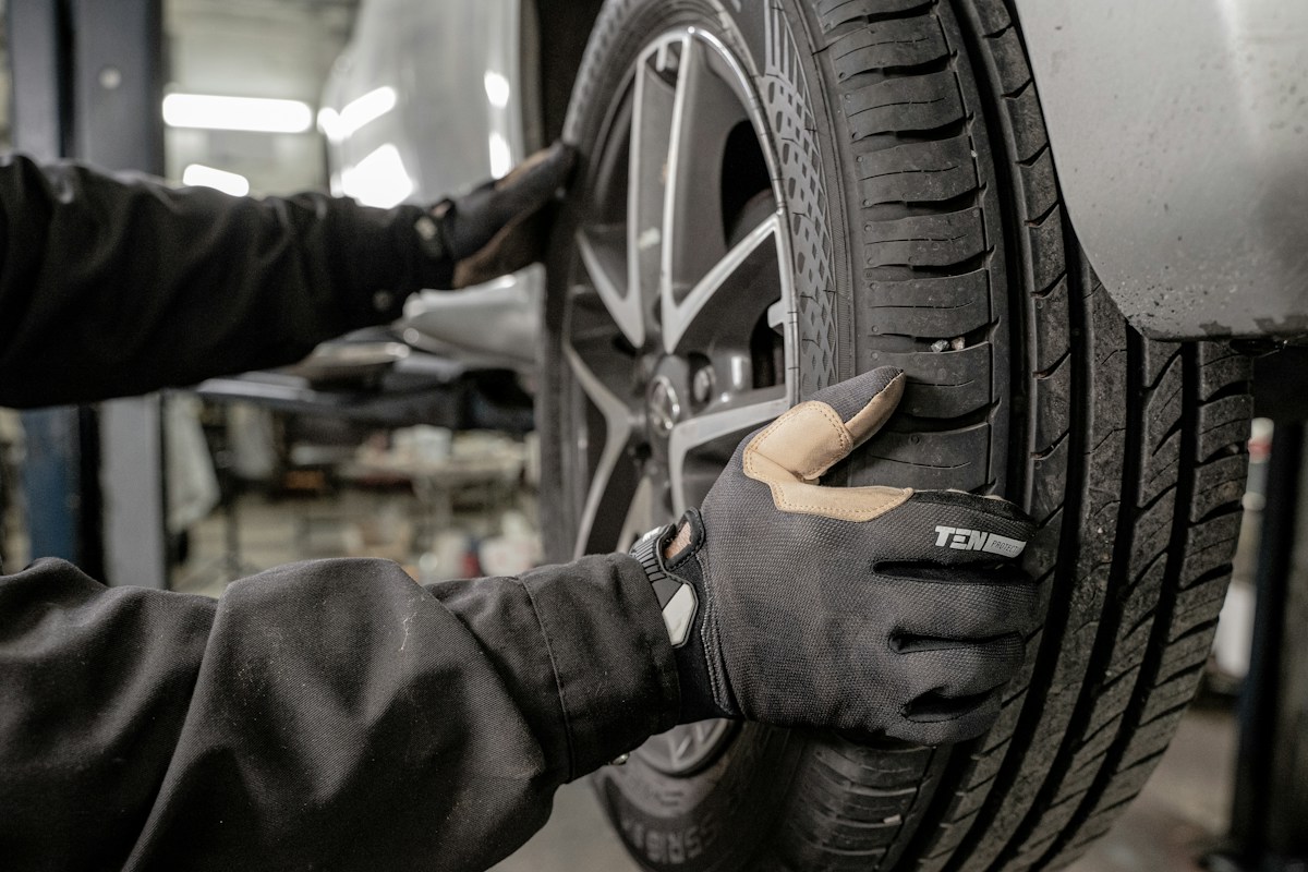 Reifentechniker arbeitet am Fahrzeugrad – illustrative Aufnahme