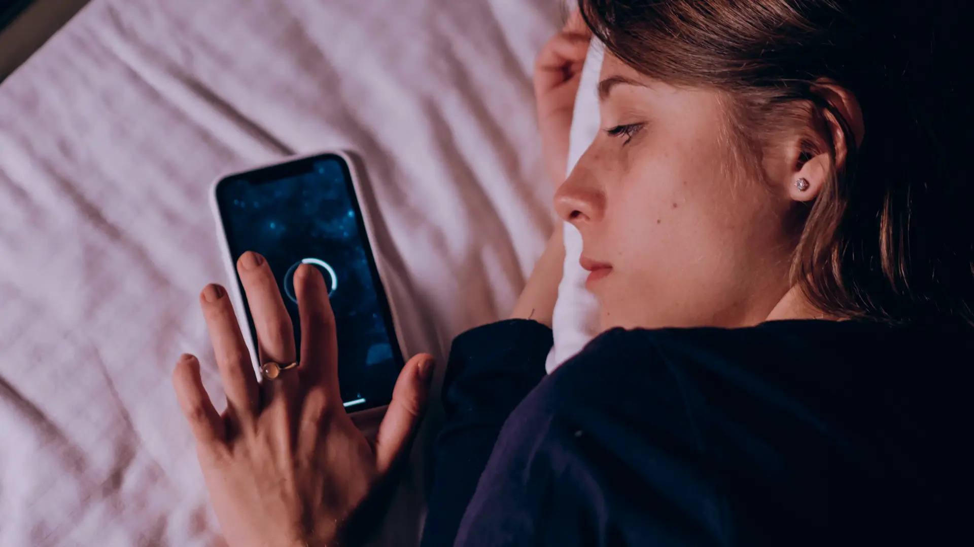 A woman uses mobile while sleeping