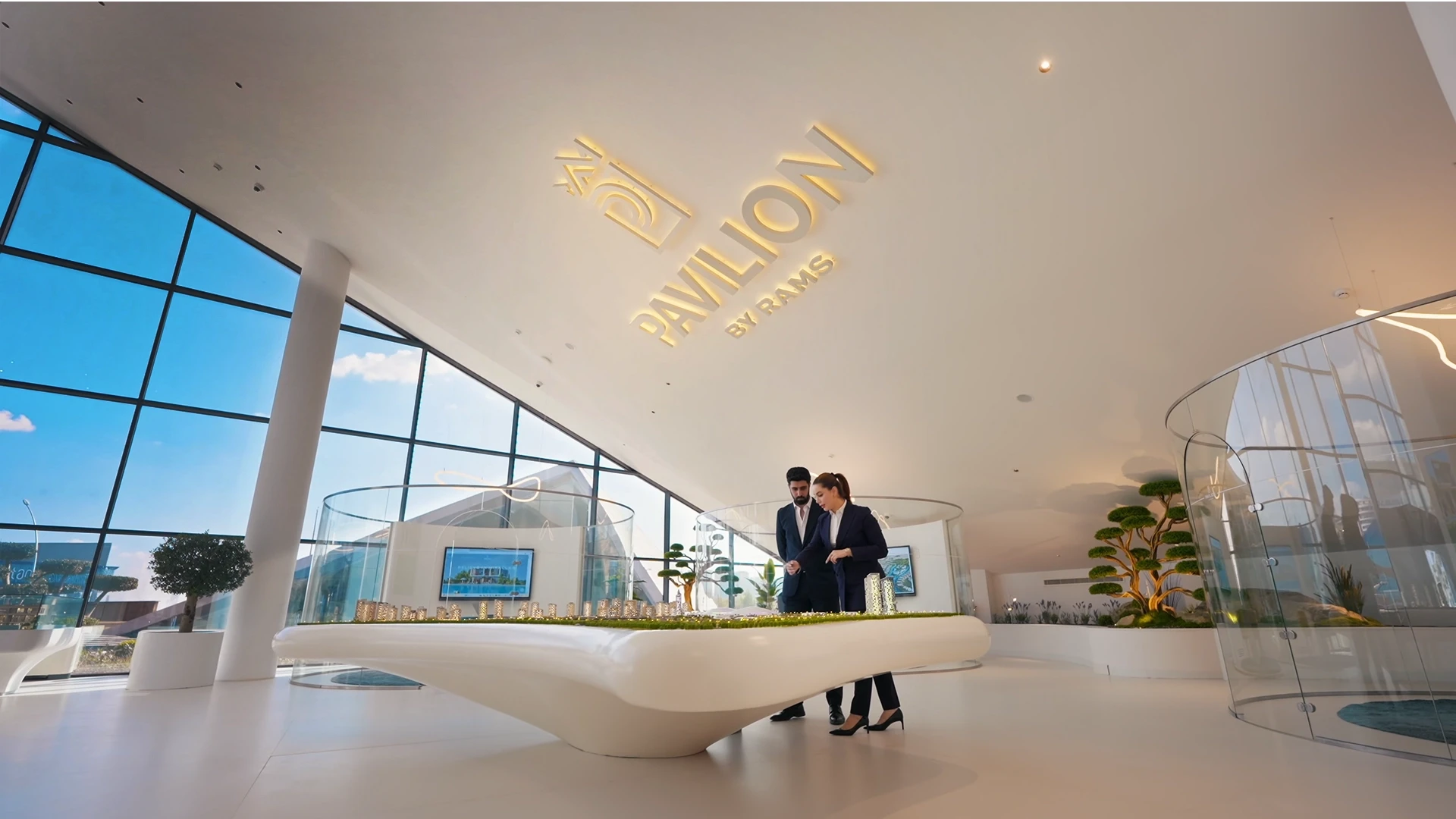 Pavilion by RAMS, elegant marketing gallery interior designed with sculptural lighting and panoramic glass walls, creating an immersive architectural experience that merges sophistication with brand storytelling.