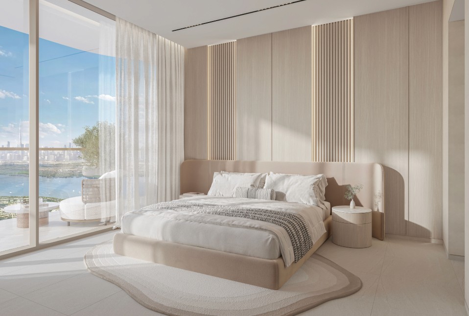 A stylish bedroom with a beautiful view of the water, highlighted by a large window, from The Caden by Prescott.