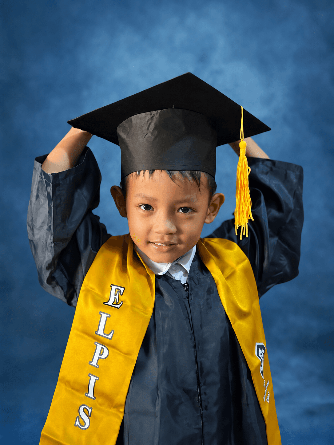 Kindergarten student at Elpis International School wearing a graduation cap and gown in Yangon, Myanmar