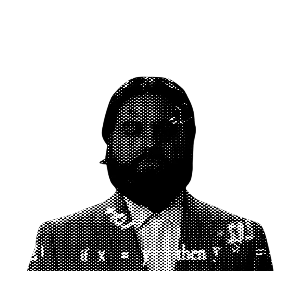 Un hombre con barba y bigote, vestido con un traje, mirando pensativamente a la cámara.