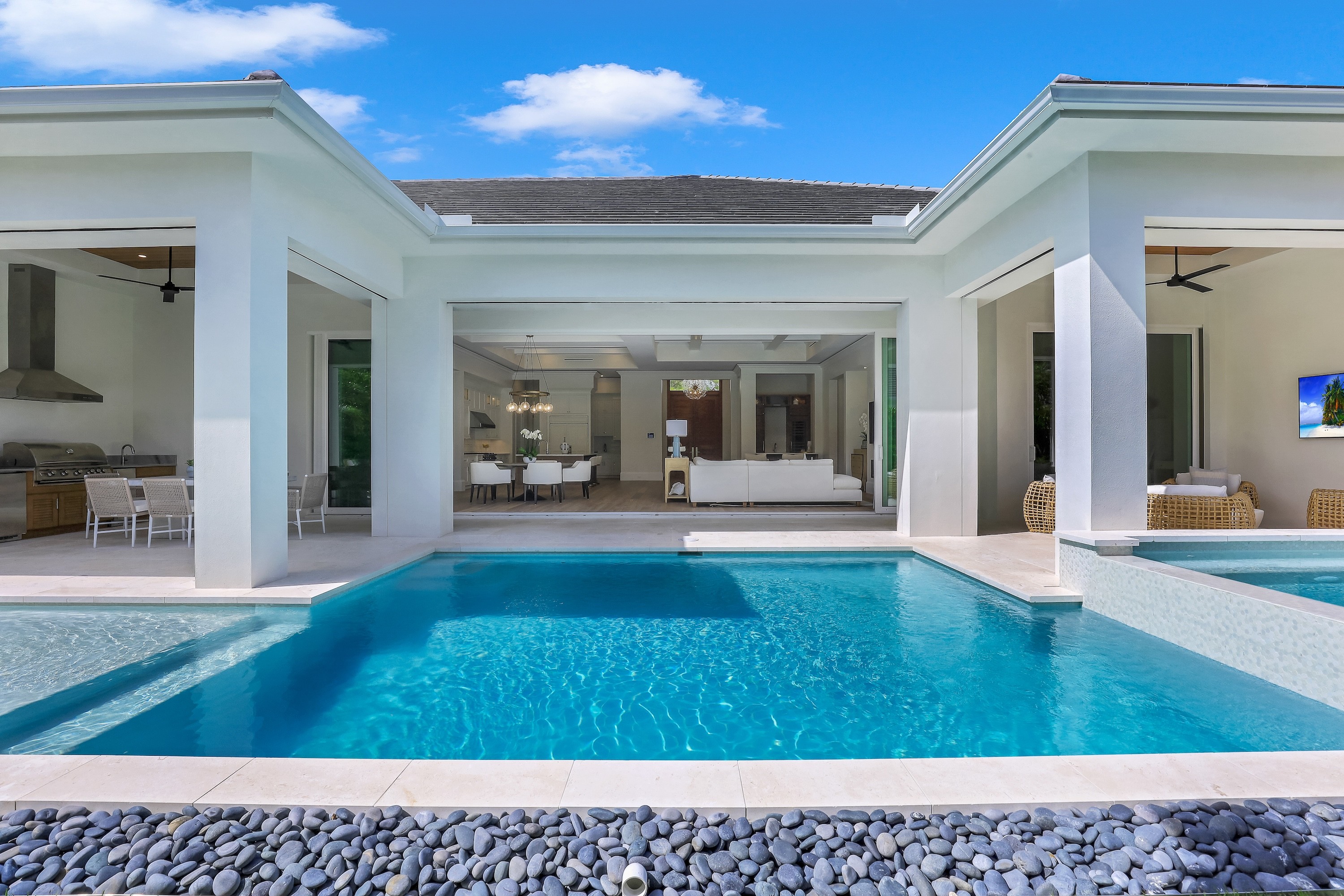 a luxurious modern pool with white columns and sharp geometric architecture