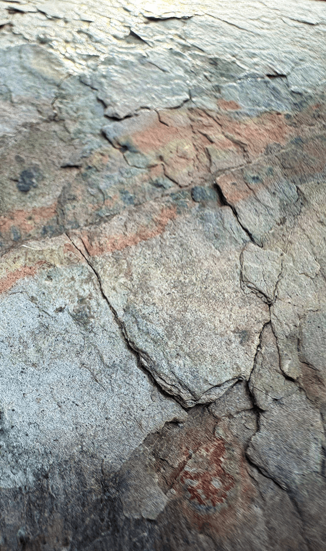 Detail of millimeter-thin natural slate exterior showing cracked stone texture and layered structure.