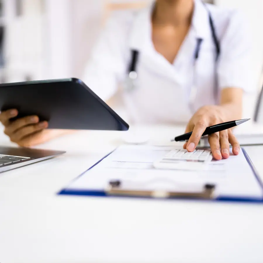 AI medical coder assists a healthcare professional using a tablet and calculator to input patient data on a clipboard