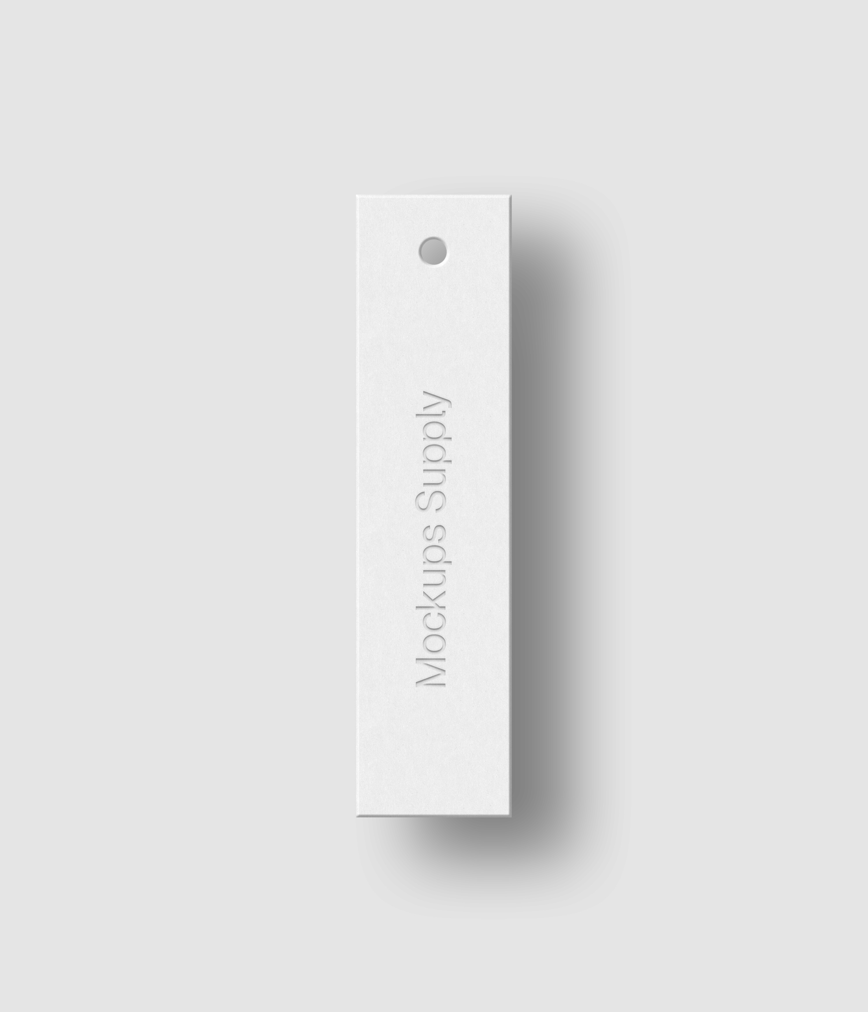 White 1x4 slim hang tag mockup on white background with soft shadow and debossed text effect for Photoshop download psd