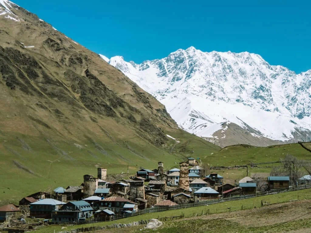 Mountain village beneath snowy peaks