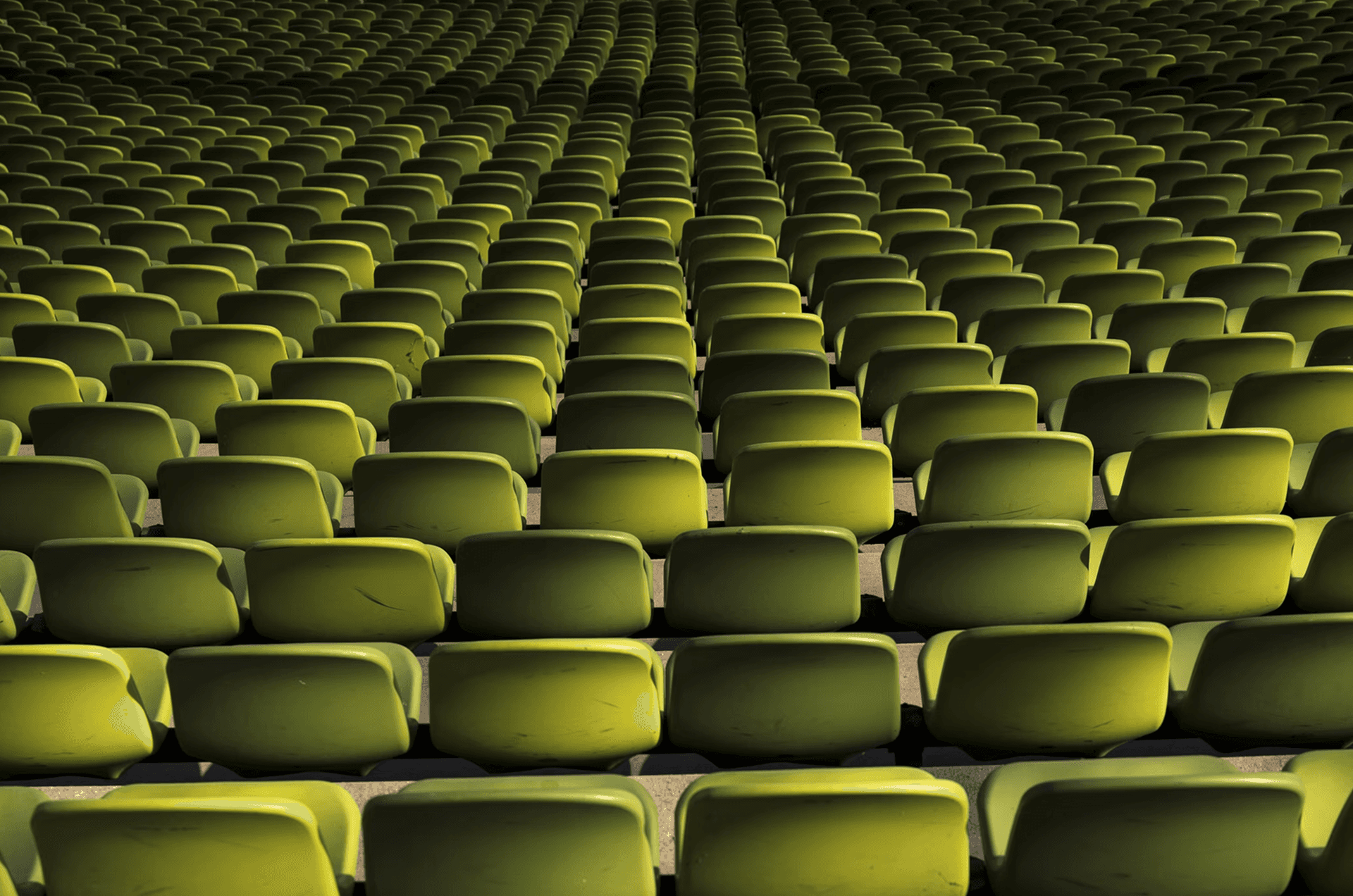 Rows upon rows of empty green stadium seats extending into the distance, representing a vast database of prospective leads for B2B data prospecting