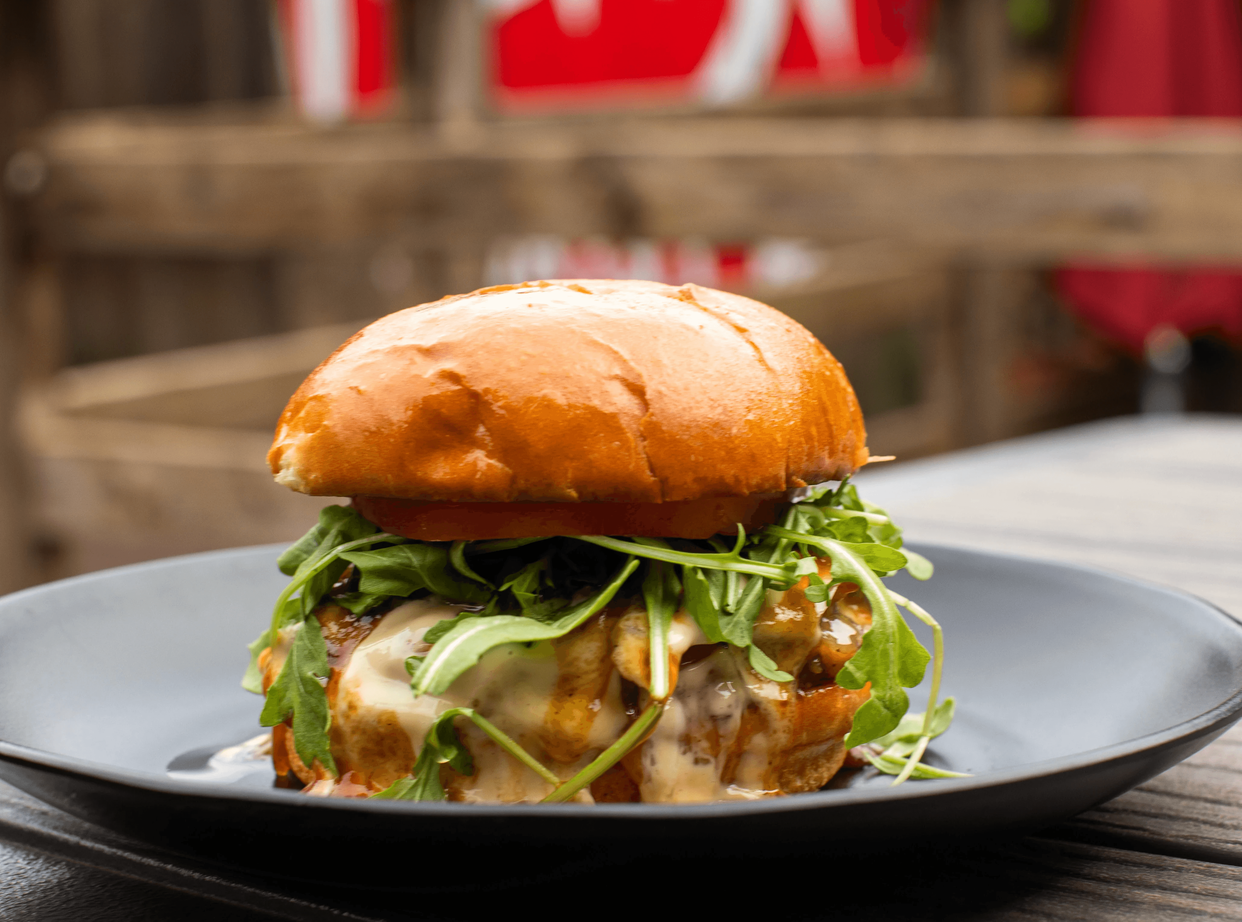 Close-up of a delicious-looking wrap, filled with richly seasoned meat and fresh vegetables, served on a white plate with extra onion and parsley garnishes.