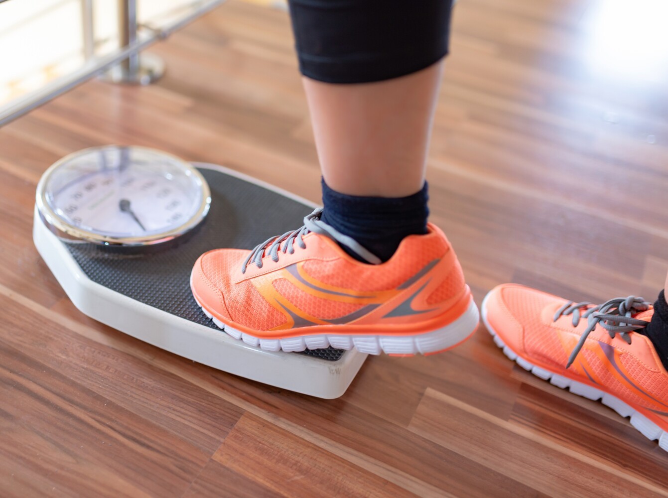 person stepping on a scale to check their BMI to see if prescribed weight loss pills are right for them