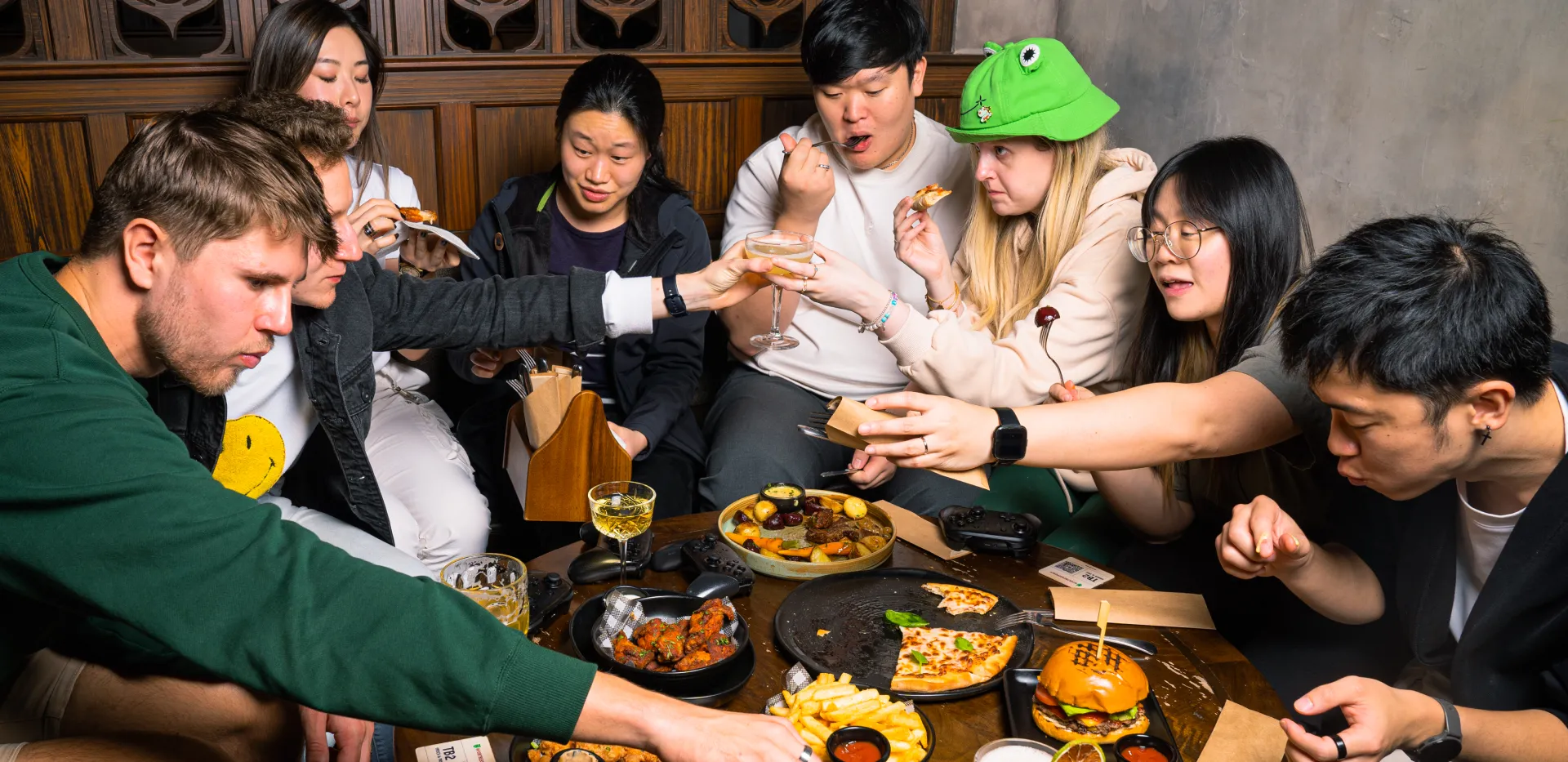 4 people engaged with someone offscreen, holding gaming controllers in their hands