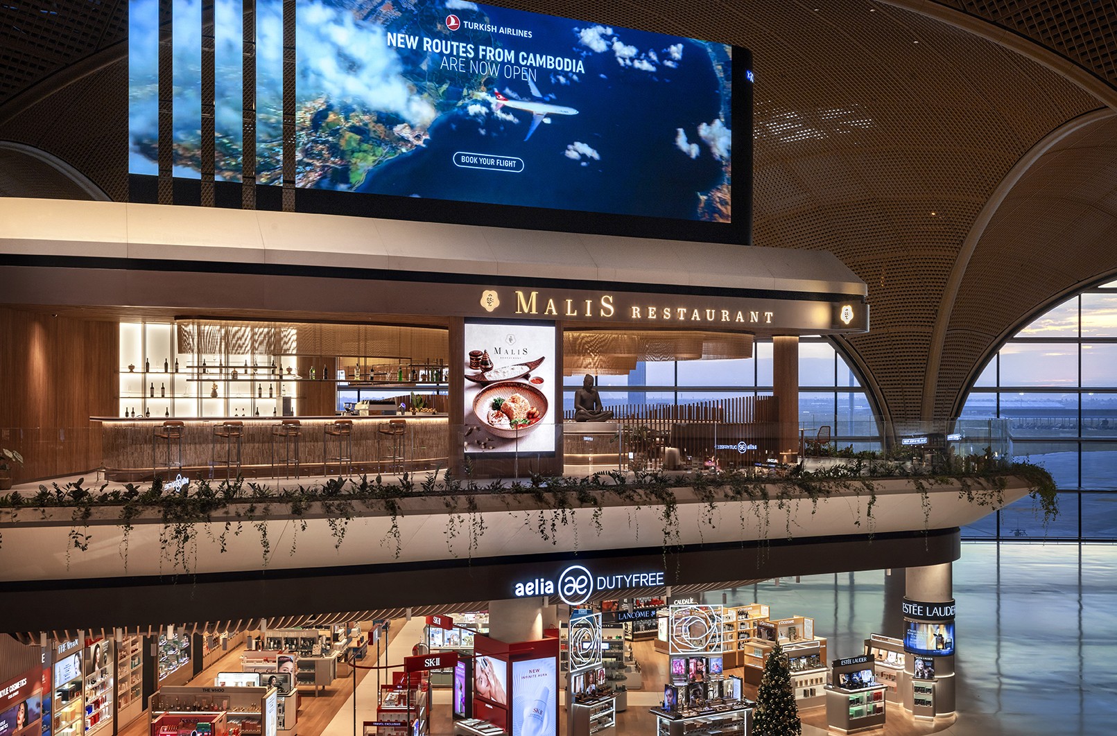 Architectural view of the elevated Malis Restaurant facade positioned above the duty free retail zone at Techo International Airport