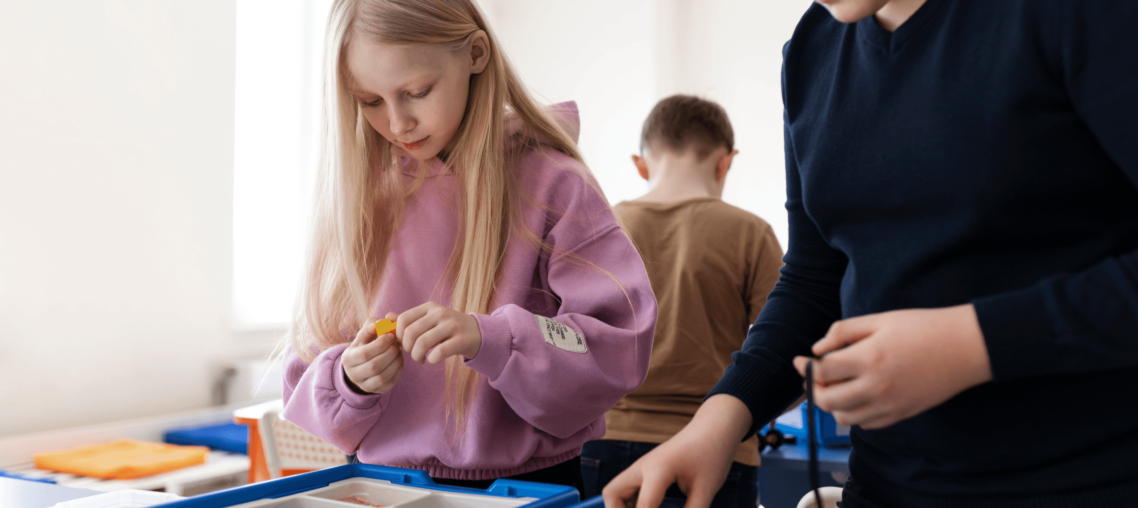 Children using pieces to build a robot.