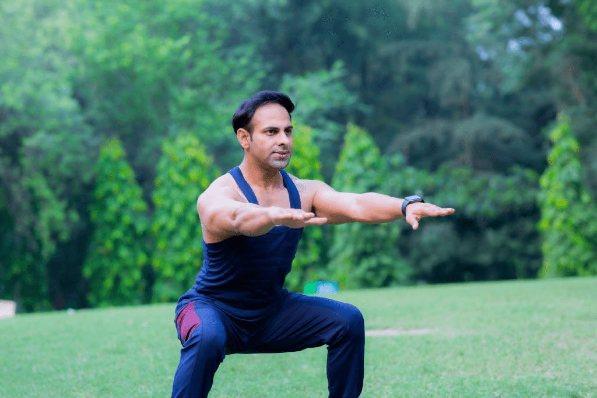 Indian man exercising in a park performing squats, showcasing fitness routines for a healthy lifestyle.