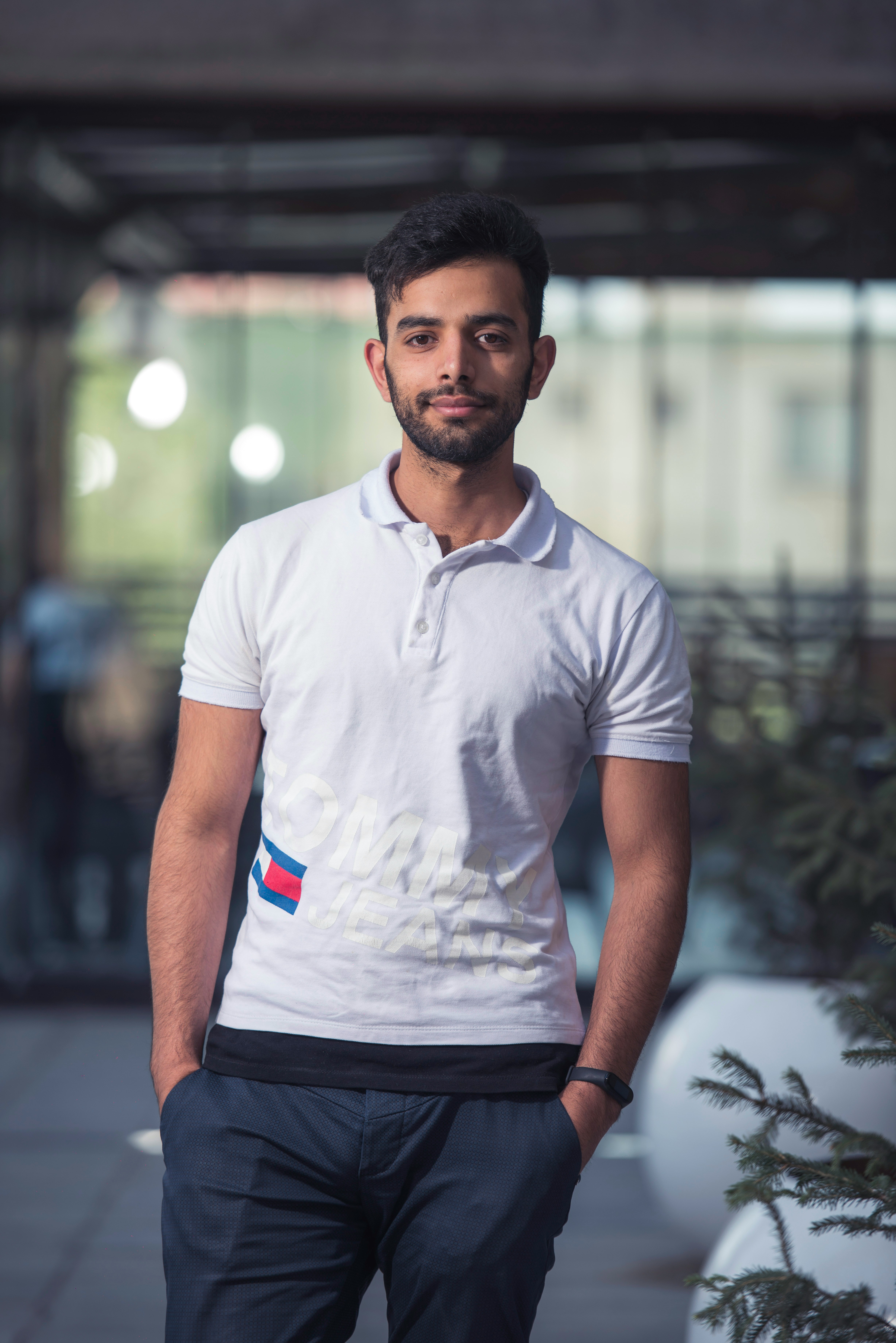 man in white crew neck t-shirt standing on road during daytime