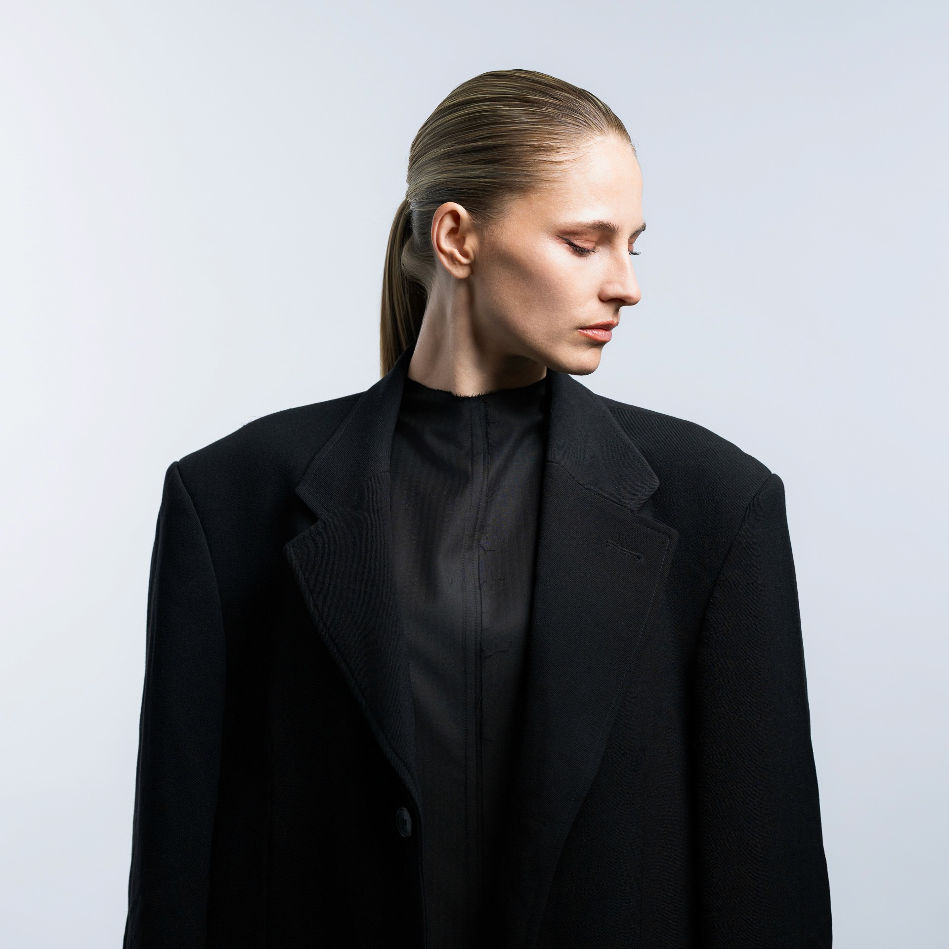 Elegantes Business Portrait einer Frau im schwarzen Blazer vor neutralem Hintergrund, Personal Branding Foto in Zürich.