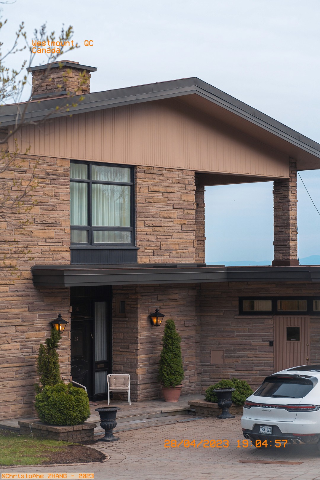 Façade en pierre d'une maison moderne à Westmount, Québec, avec une voiture garée devant.