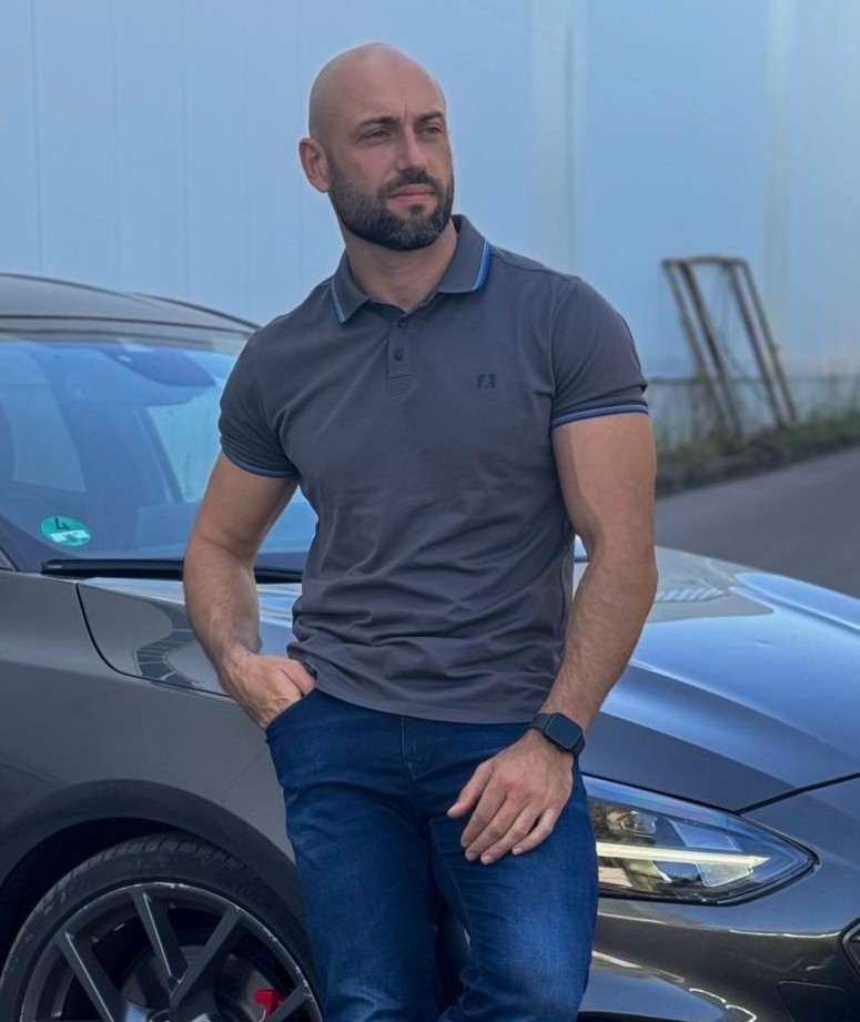 A car salesman standing next a car