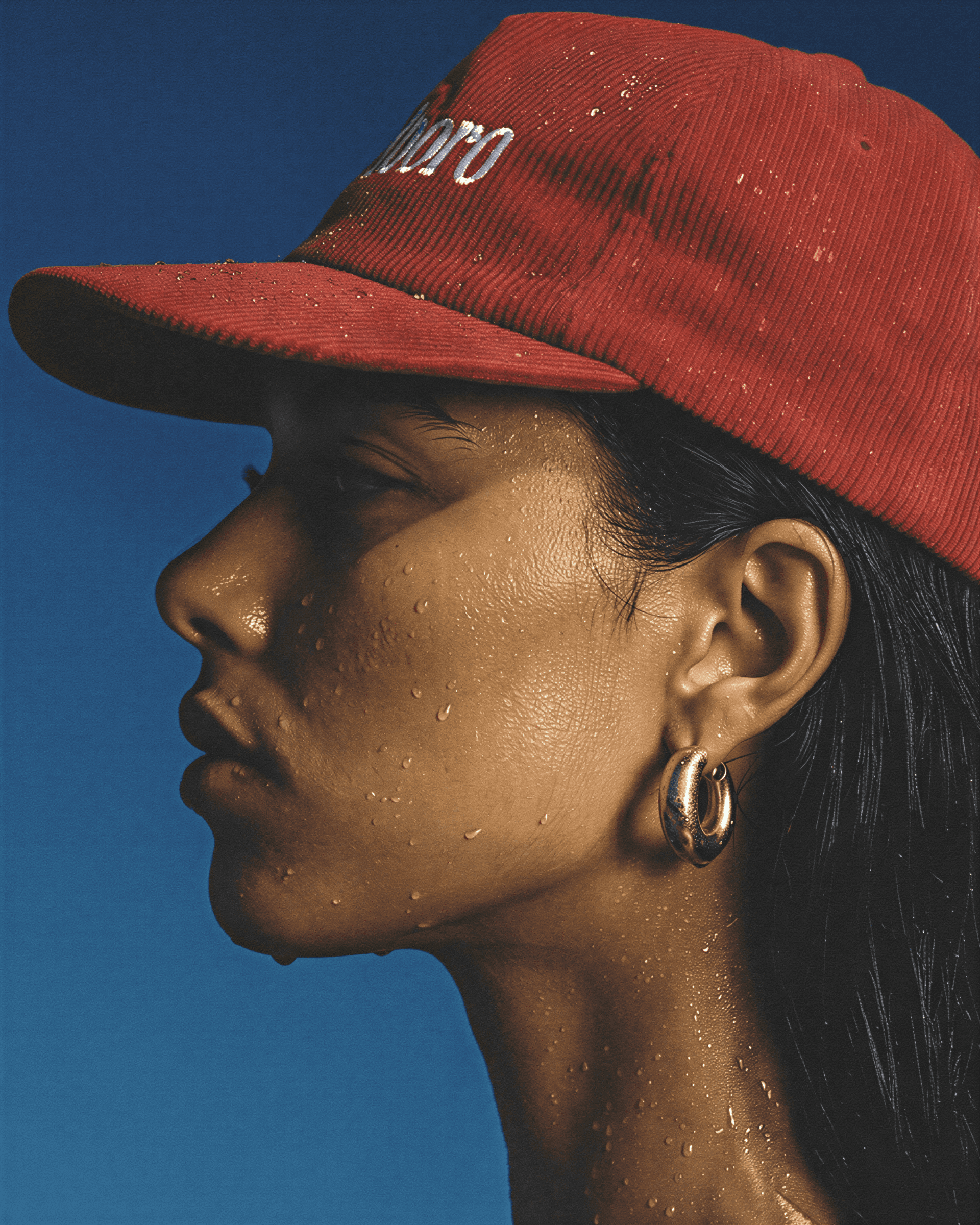 Person wearing a red cap with 'Café' text against a blue background