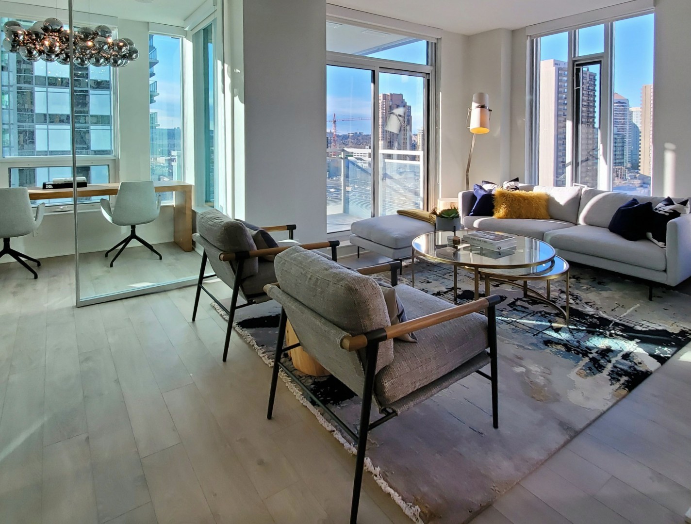 Image of Modern living room with sofa, chairs, coffee table, and city view, showcasing KHD Homes interior design expertise.