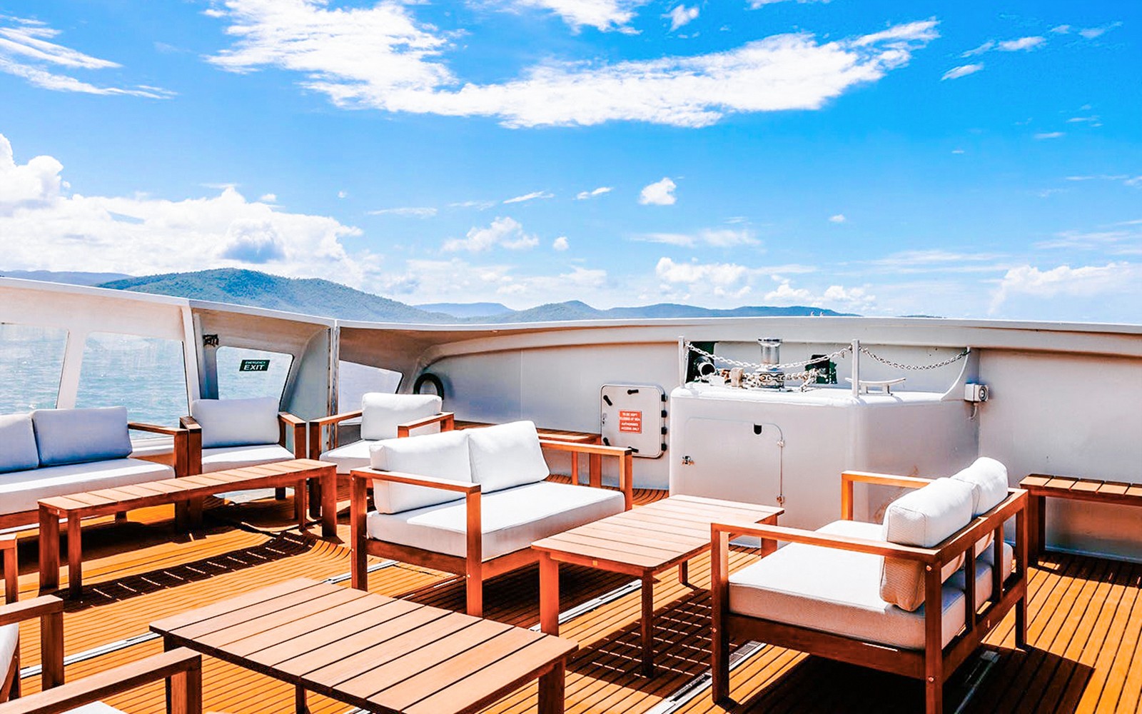 אזור ישיבה חיצונית על סיפון סירה במהלך סיור יום ZigZag Whitsundays.