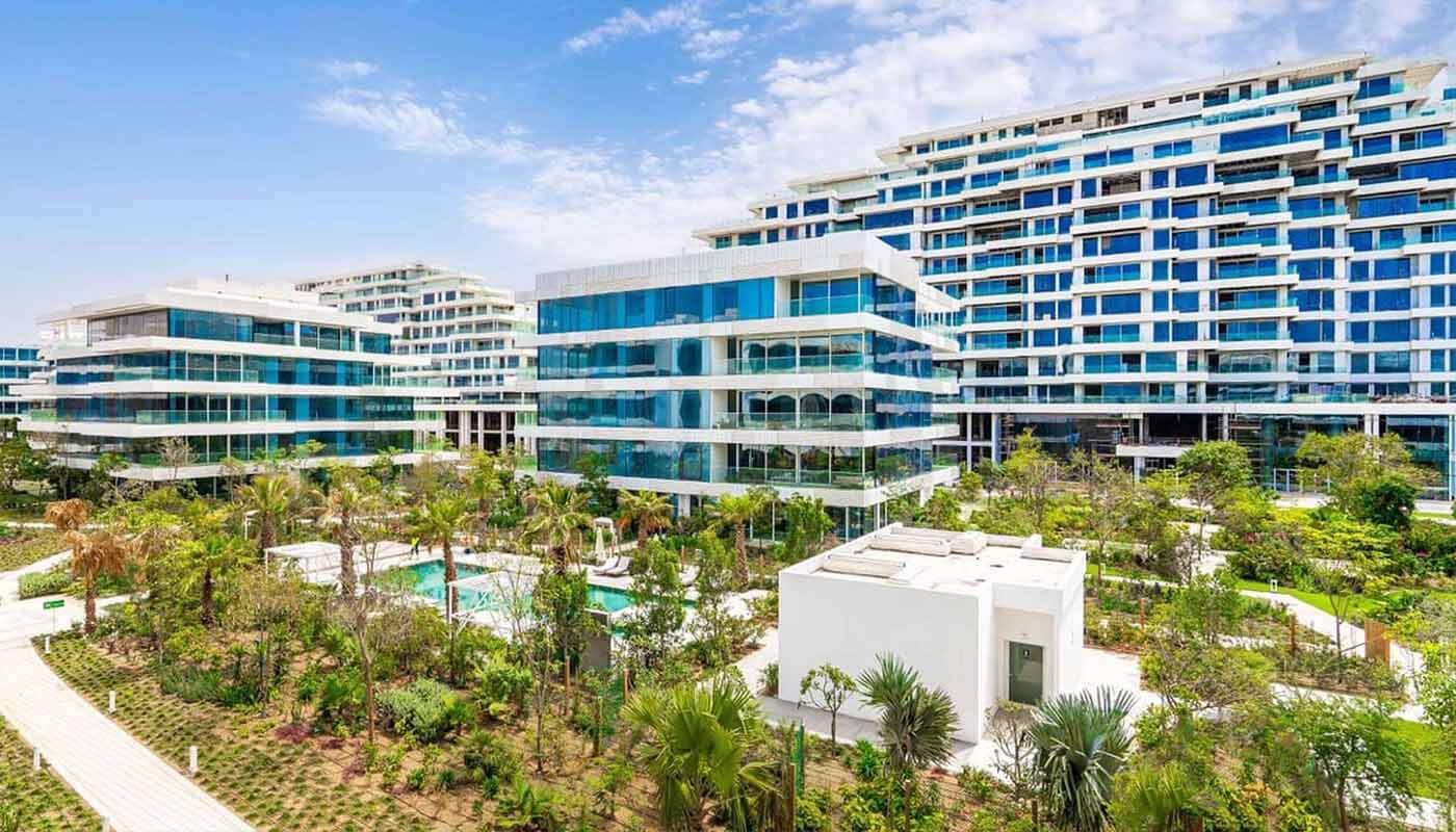 Sunset view from a high-rise building, with the sky painted in warm colors and silhouettes of distant city buildings.