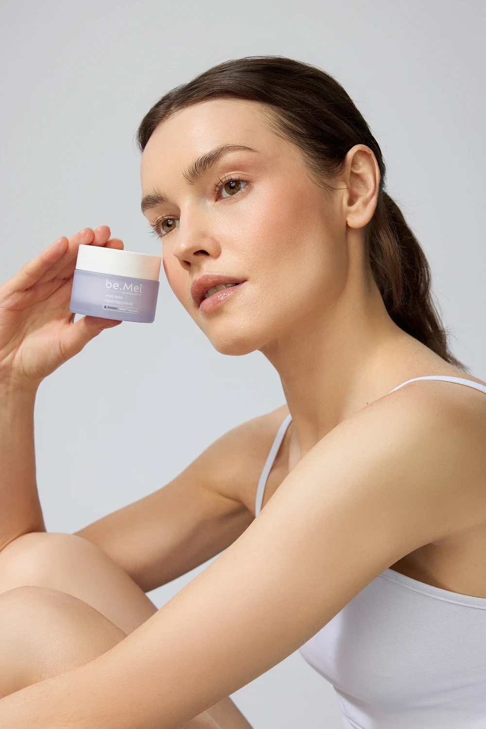 Kobieta z kremem do twarzy w ręce