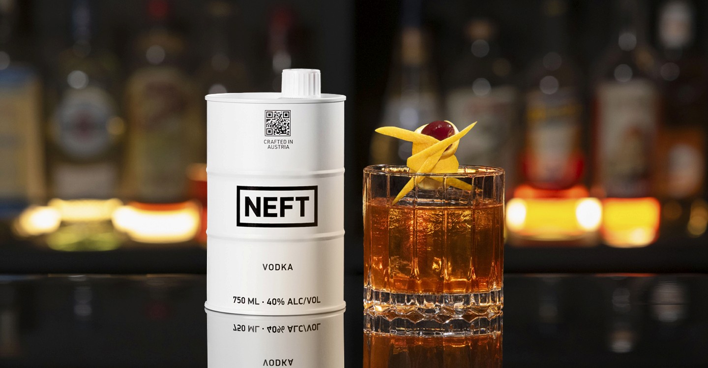 A NEFT Barrel and a glass of Prohibition Old Fashioned on a bar counter.