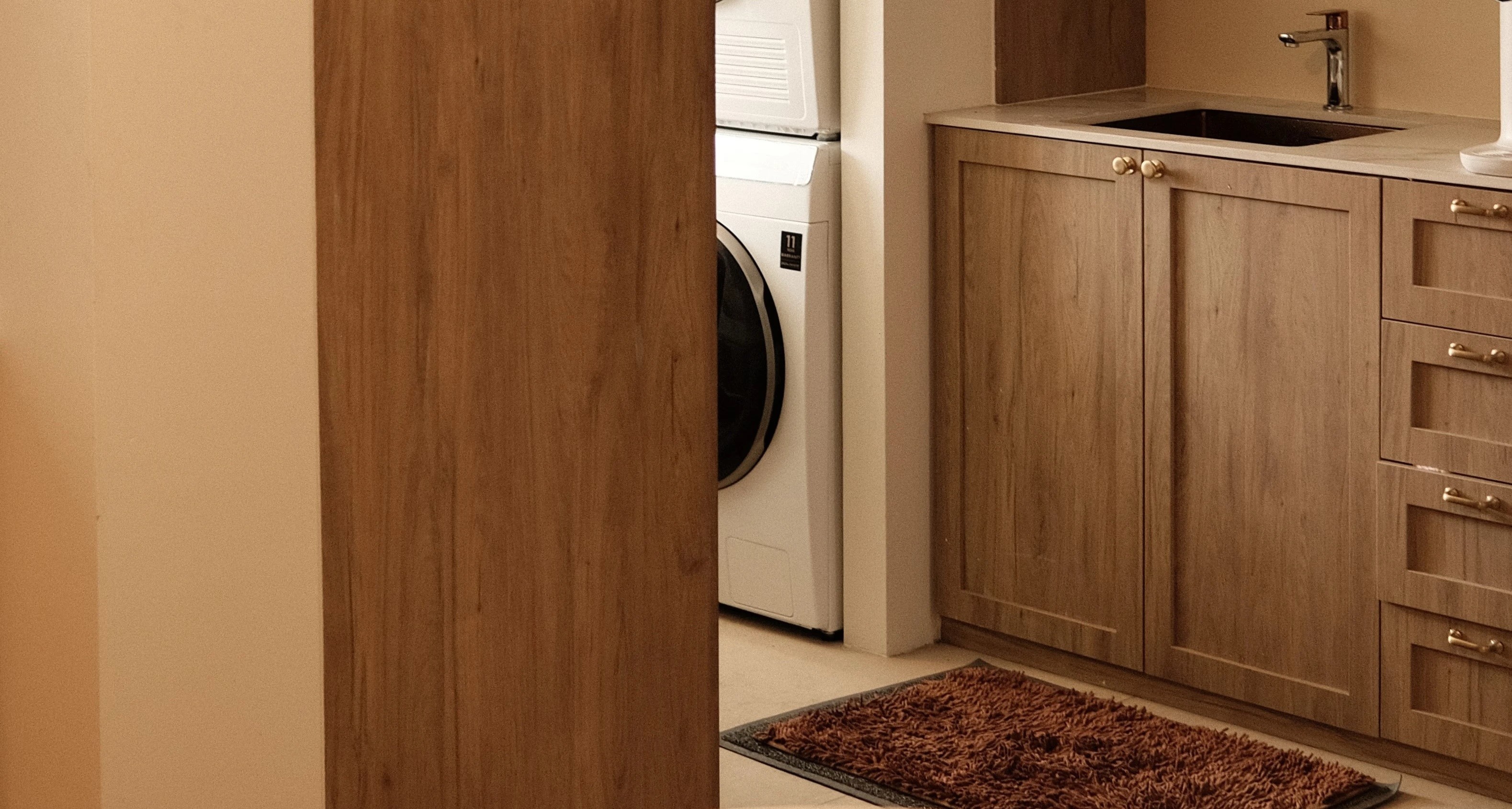 Functional foyer with built-in cabinetry and warm wood finishes, custom storage solution by Persqft